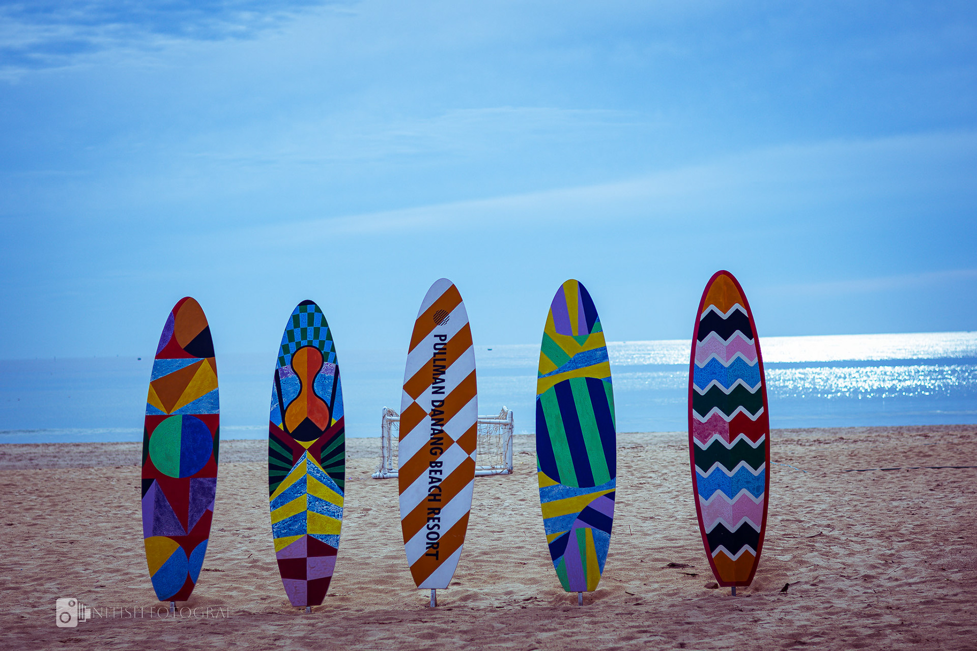 Vibrant surfboards lined up against a backdrop of endless skies and sandy beaches