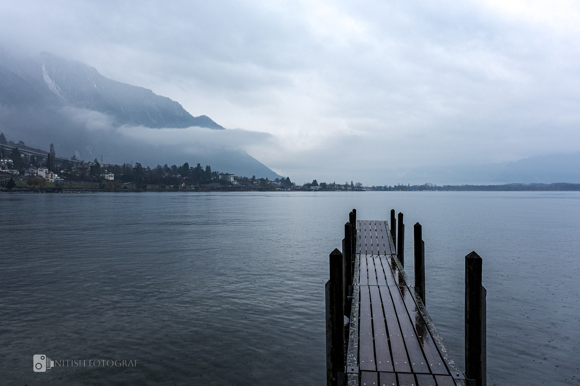 A wooden pier stretching into the stillness of an endless lake