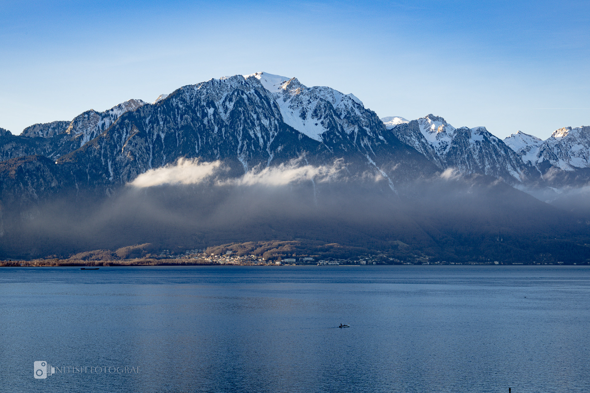 A calm alpine lake reflecting the surrounding peaks in perfect clarity