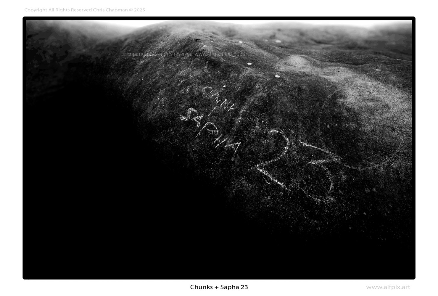 Mono image. Graffiti on a rock that reads Chunks + Sapha 23.