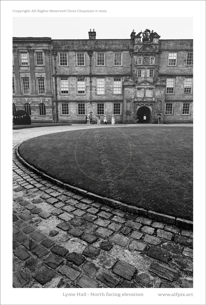 Front entrance to Lyme Hall. Cobbled road surface. Lawn. Black and Whiite.