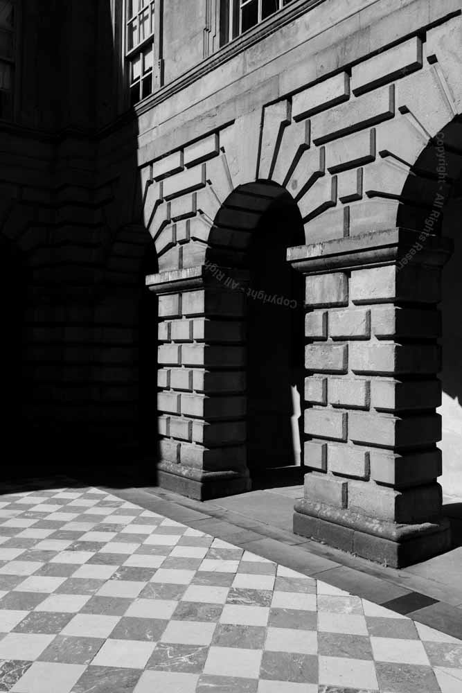 Detail of stonework of Lyme Hall Inner courtyard. Black and White. Chequered floor tiles.