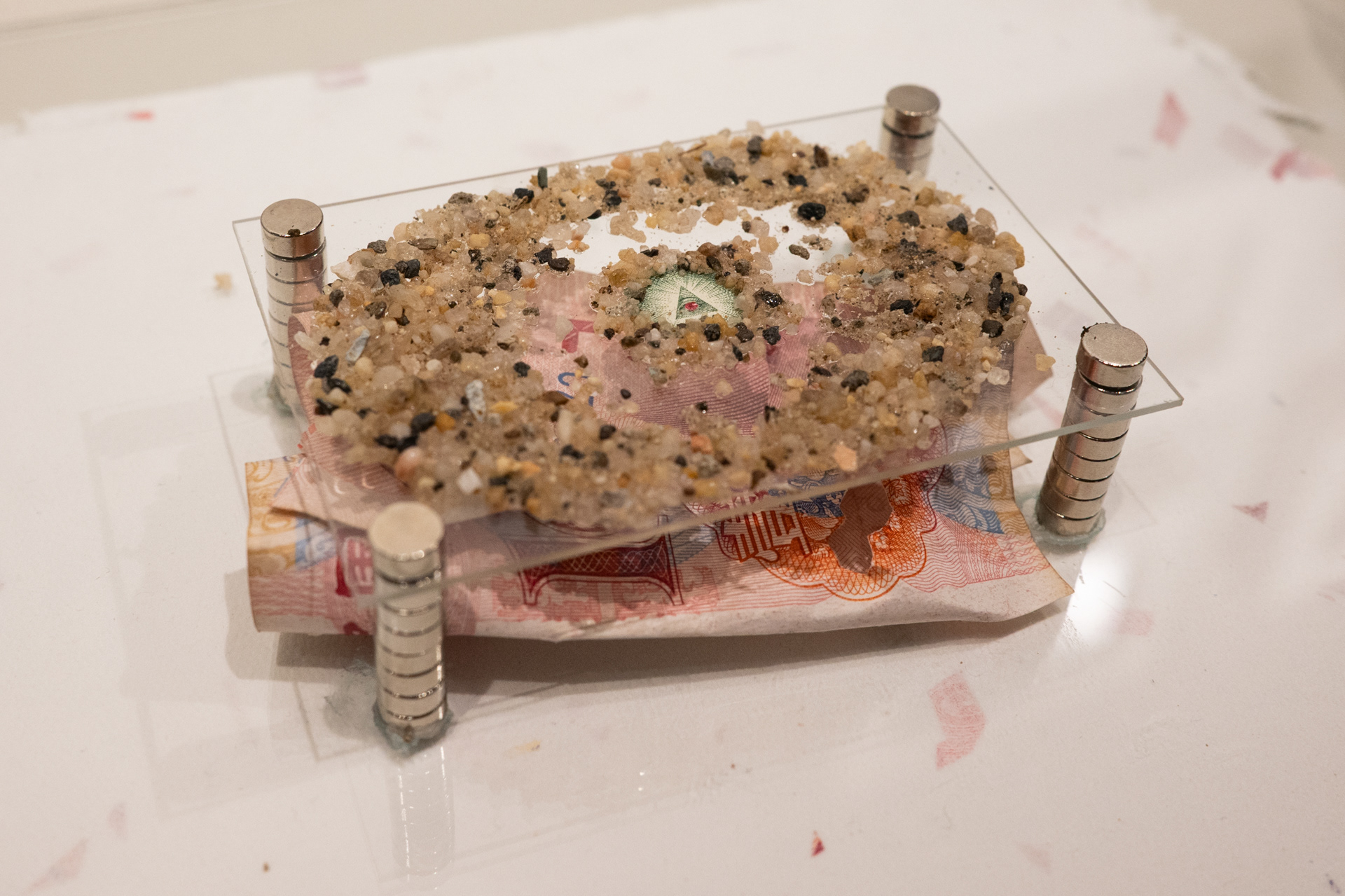 Eye of Providence, (2025, currency, sand, glass, handmade paper)