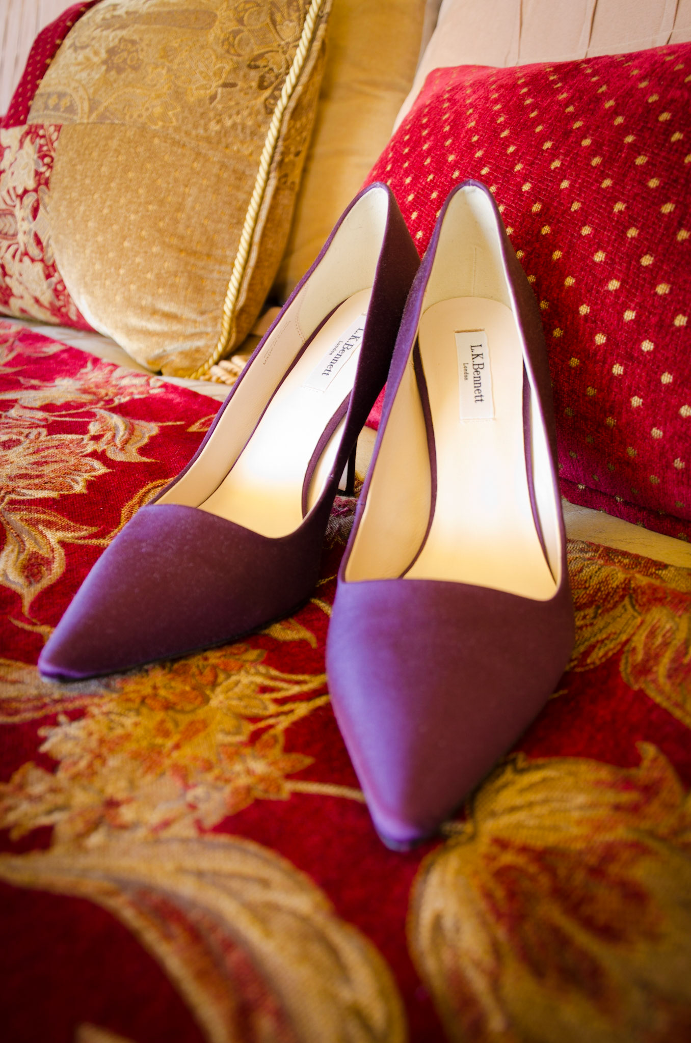 Purple wedding shoes on the bedspread