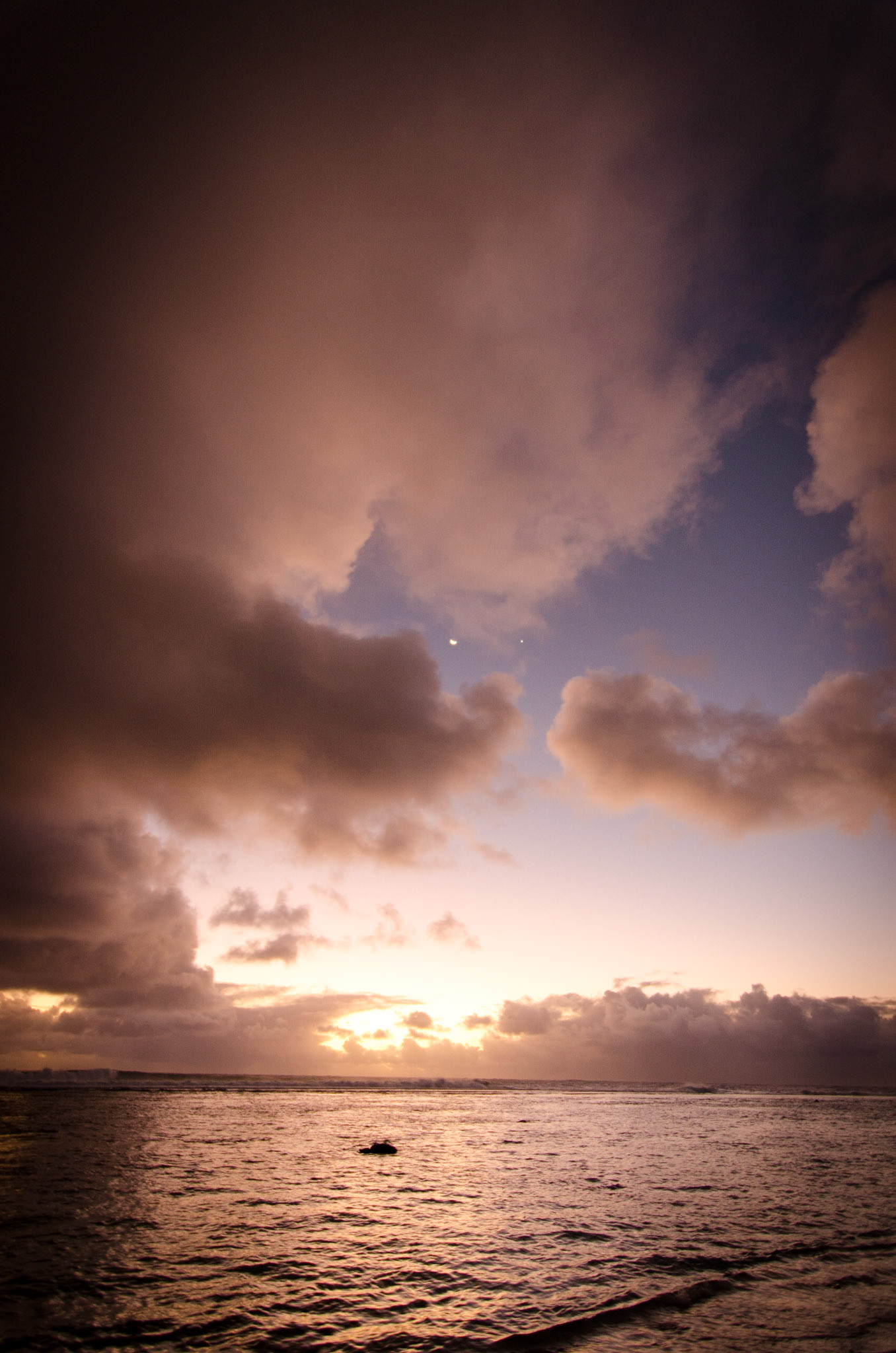 The moon rising at dusk on Crown Beach, Rarotonga
