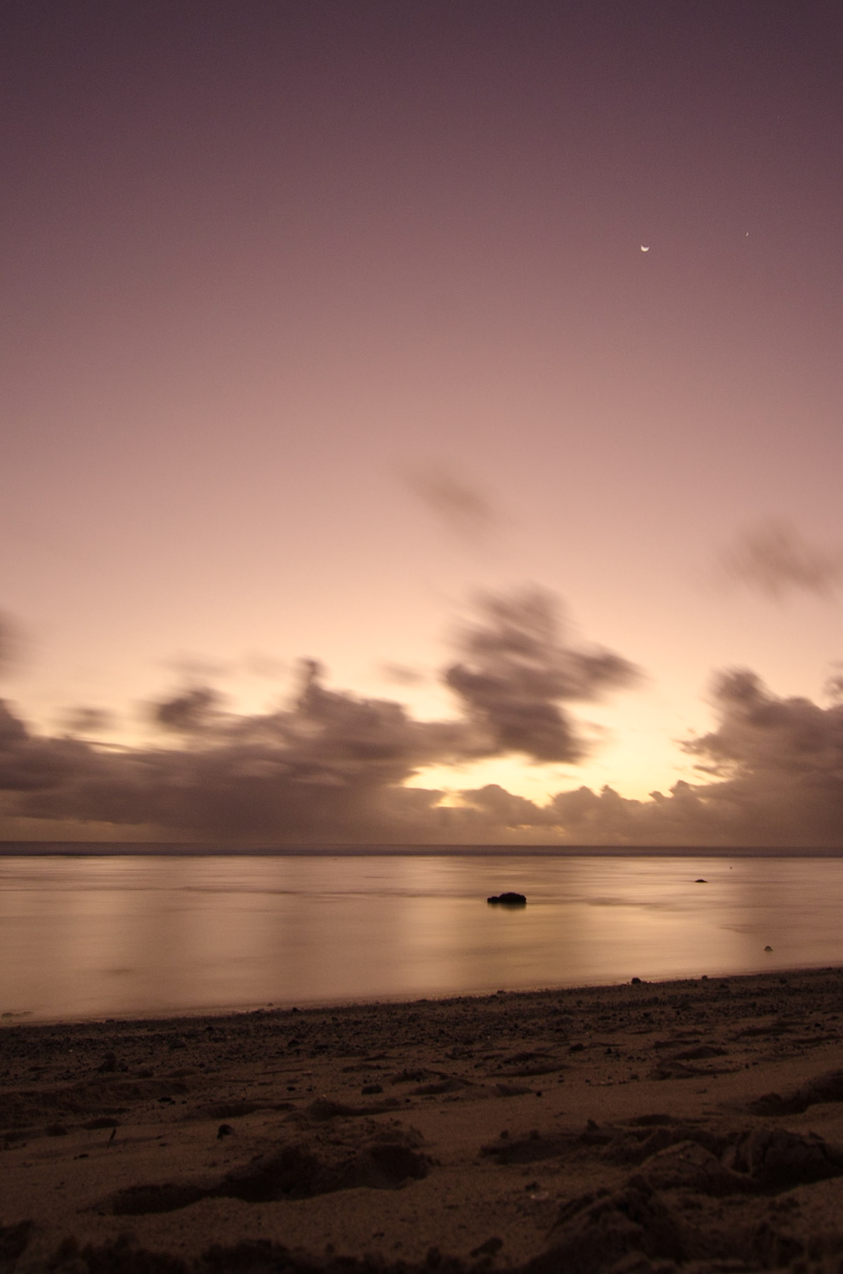 The moon rising at dusk on Crown Beach, Rarotonga