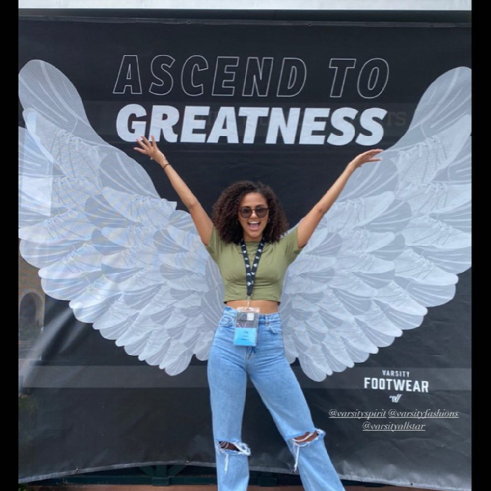One of our Varsity Spirit Fashionistas posing with the backdrop.