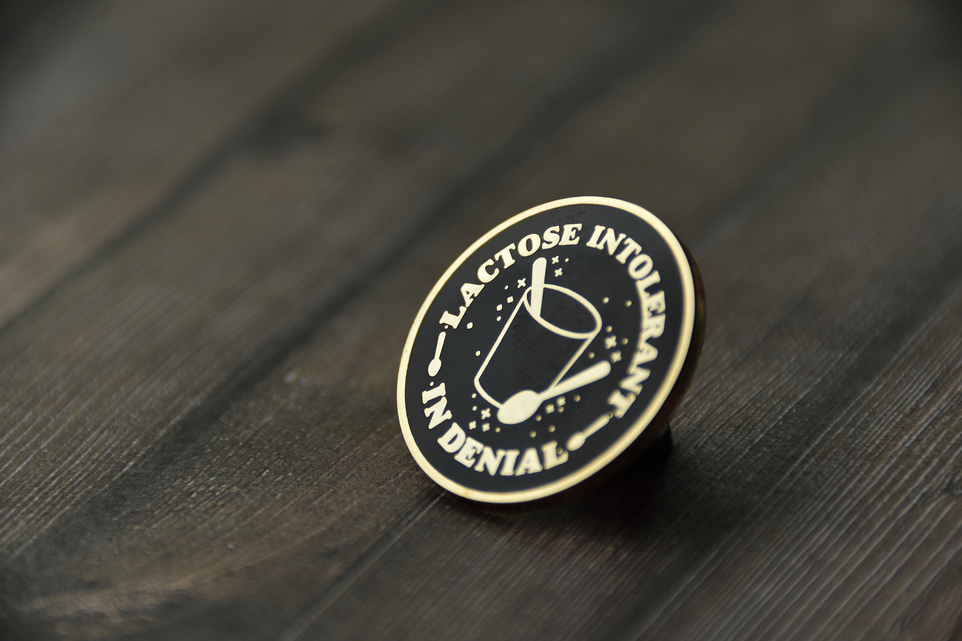 Gold-plated metal lettering is a classic enamel pin style.