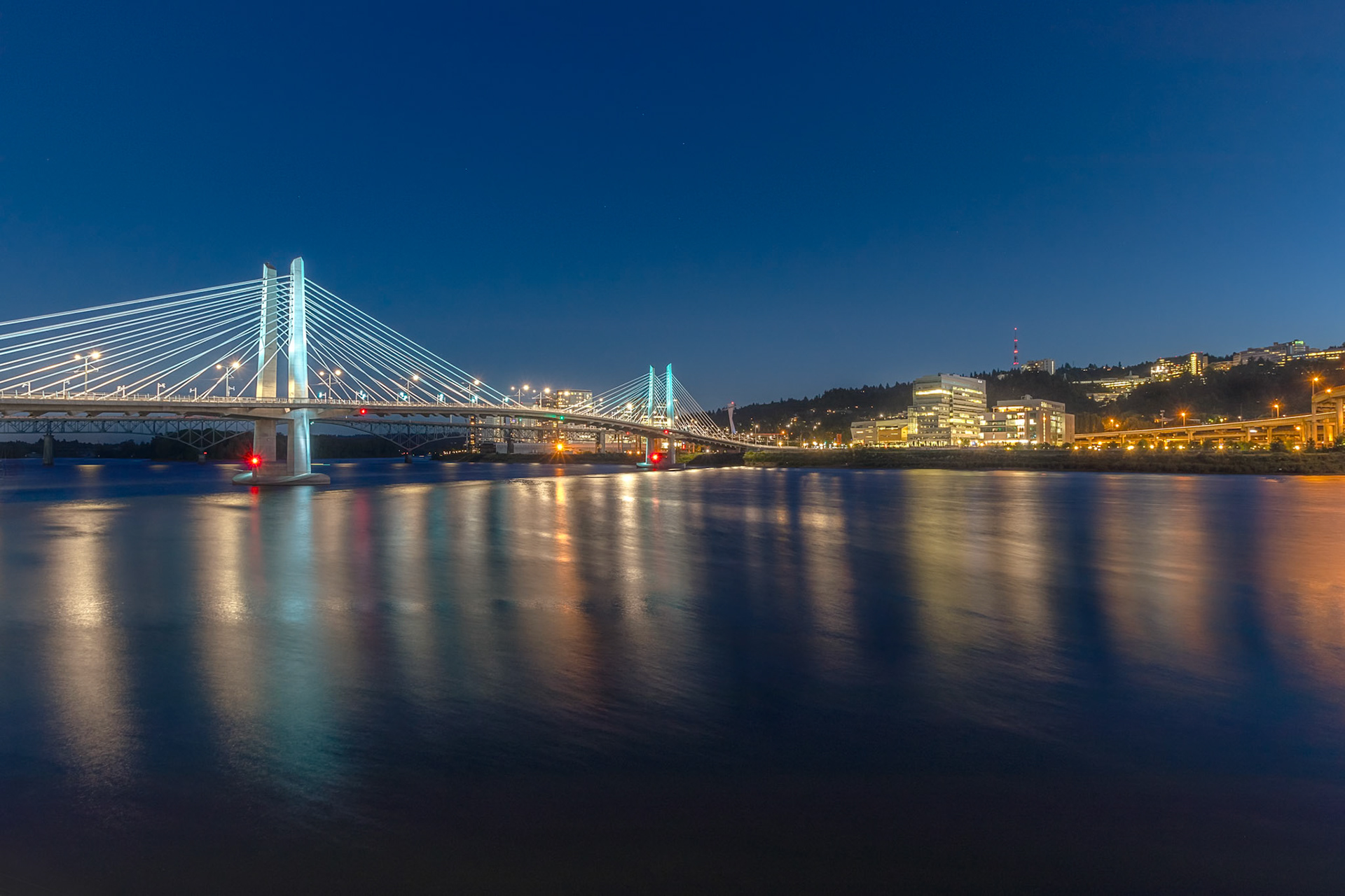 Tilikum Crossing Bridge of the People at night with lights reflecting on water Portland, Oregon