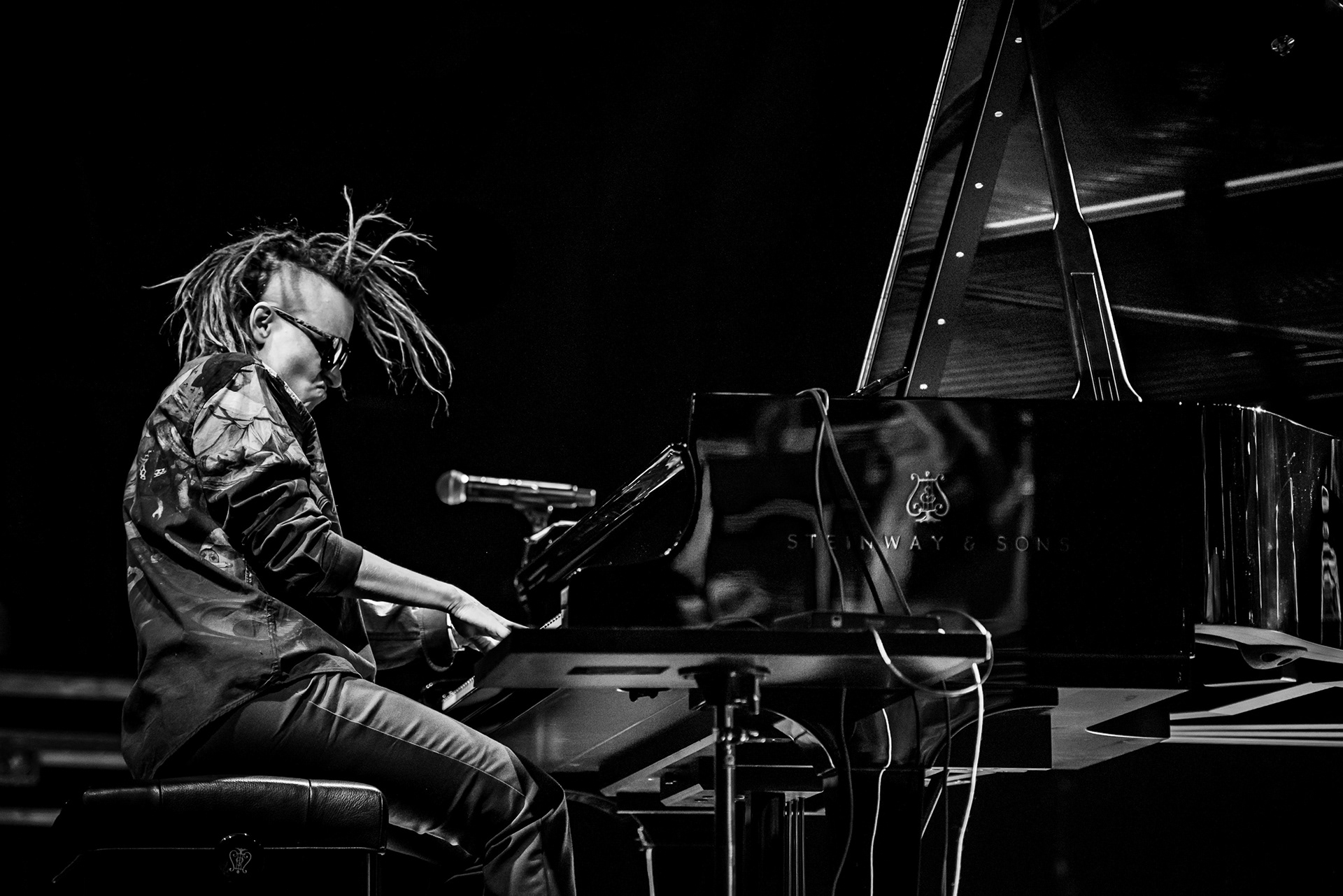 Dynamic motion and energy of Joanna Duda at the piano, artistic black and white jazz photography, capturing the spirit of avant-garde music, photo by Szymon Ratajczyk.