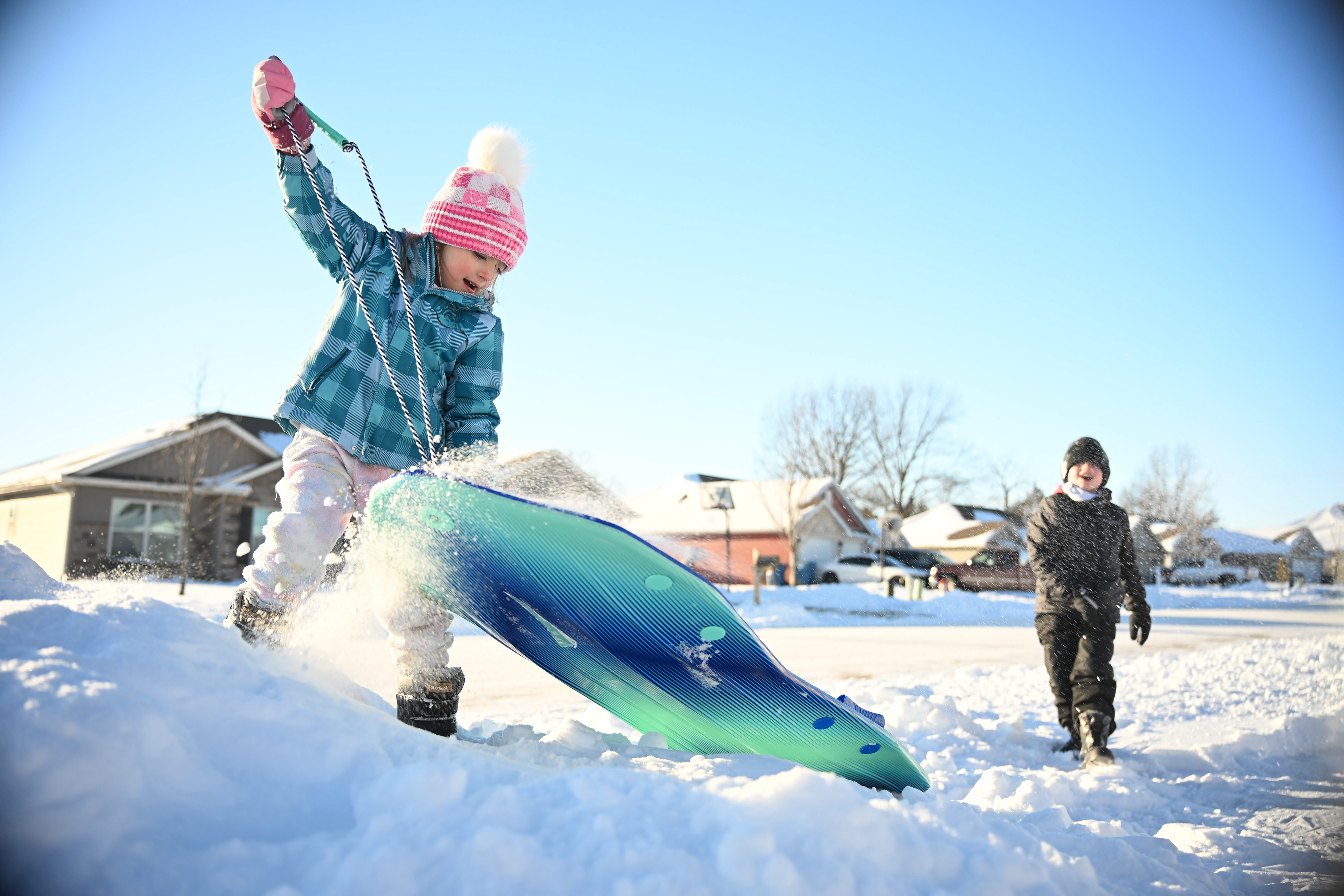 Levi Kruger, 7, right, throws a snowball toward his sister, Riley Kruger, 4, on Monday, January 26 in Ashland, Mo. Both kids enjoyed the day off from school and day care after a major snowstorm. Their father, Tanner Kruger, built up a small snowbank for the kids to sled on in their front yard.