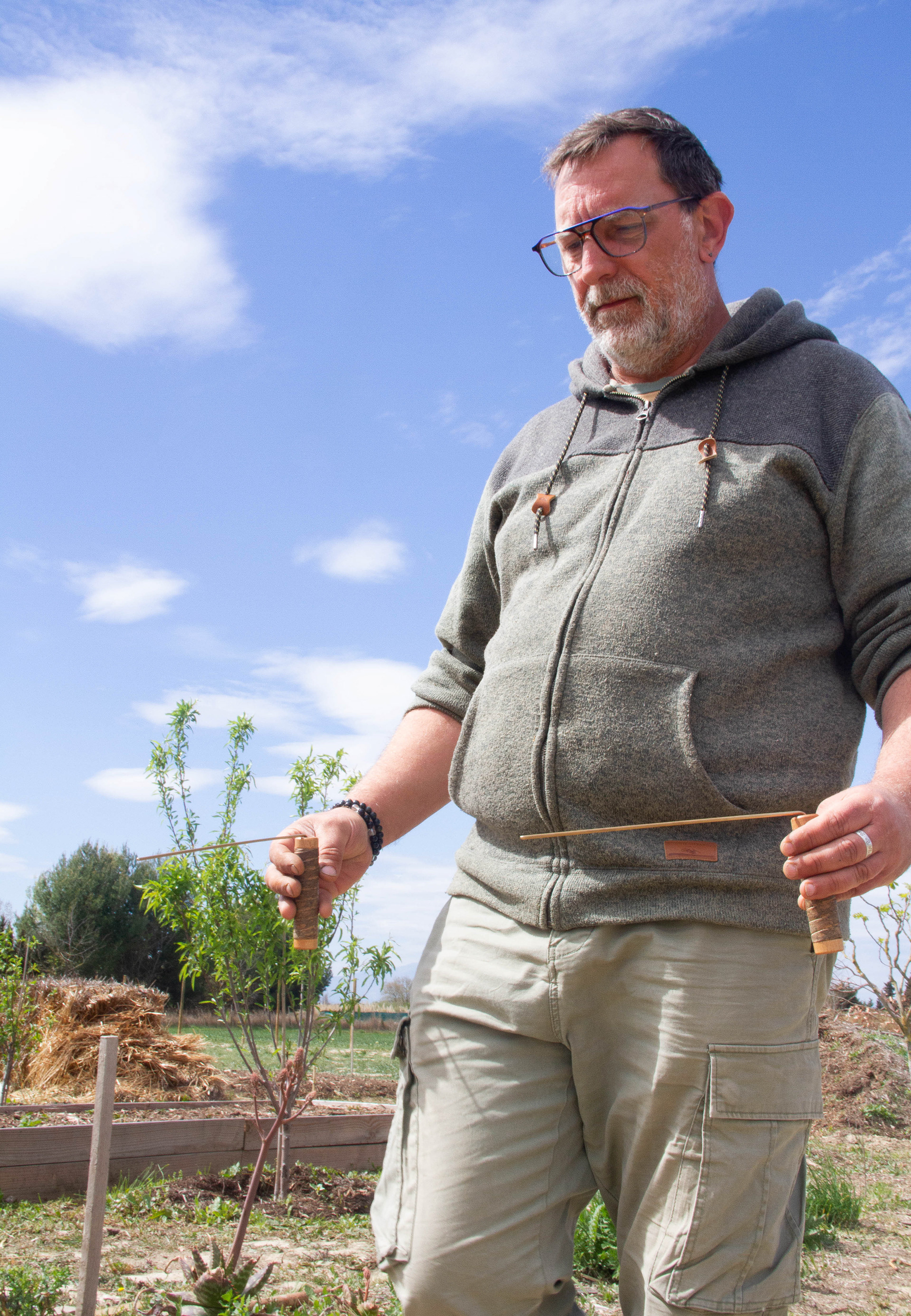 Hervé* (prénom modifié) est géobiologue et sourcier dans les Pyrénées-Orientales. Sur cette photo, il tourne le dos au Canigou, habituellement encore bien enneigé en avril. Sensible, par le biais de ses baguettes, aux cours d’eau en mouvements et à leurs variations, Hervé dit avoir ressenti des différences nettes de débits depuis le début de la sécheresse hivernale, en passant sur ses cours d’eau habituels.