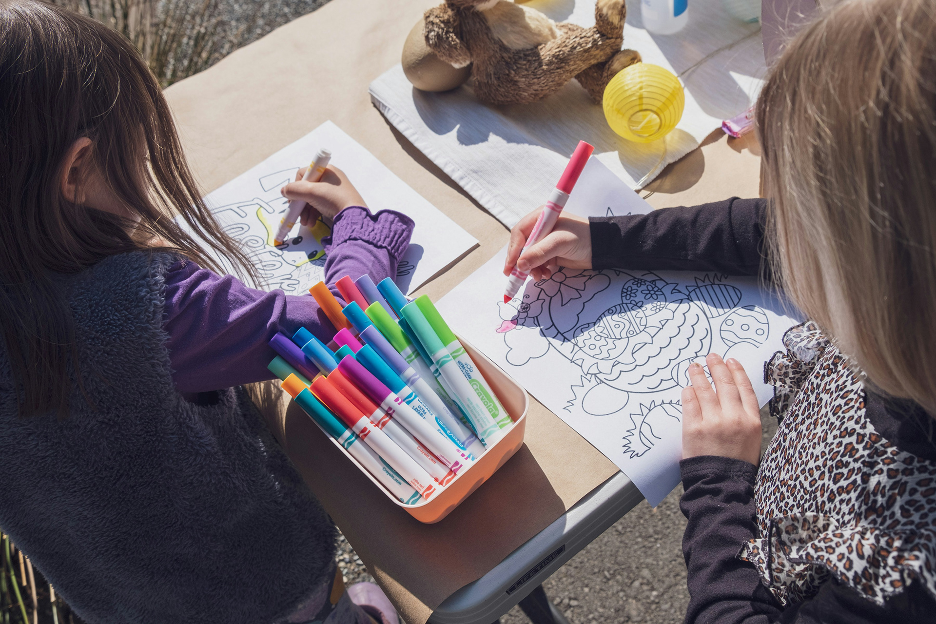 two young girls coloring with markers fun drawings