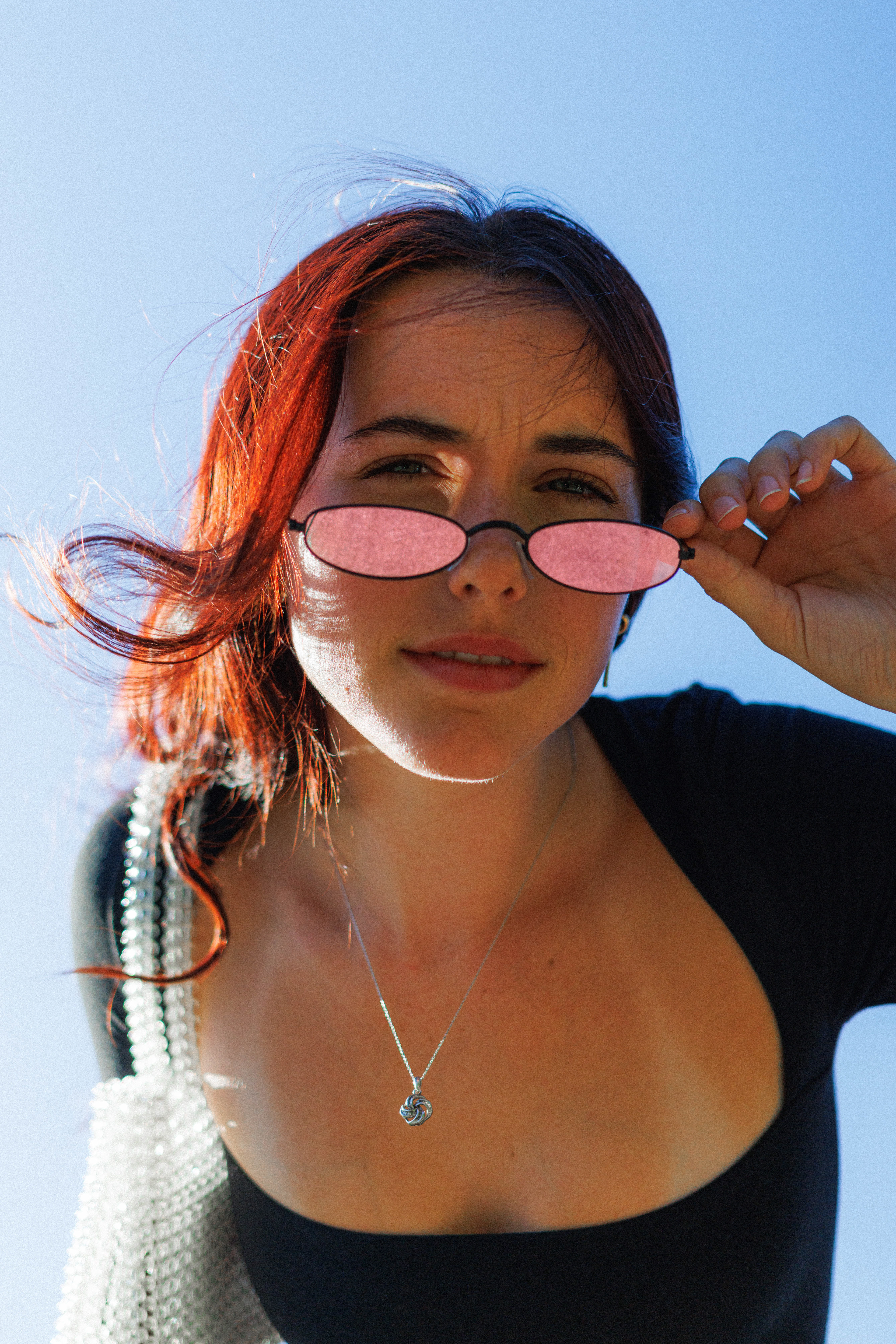 Meghan | Outdoor sunny fashion photoshoot with y2k vintage sunglasses, bodysuit, white purse close-up