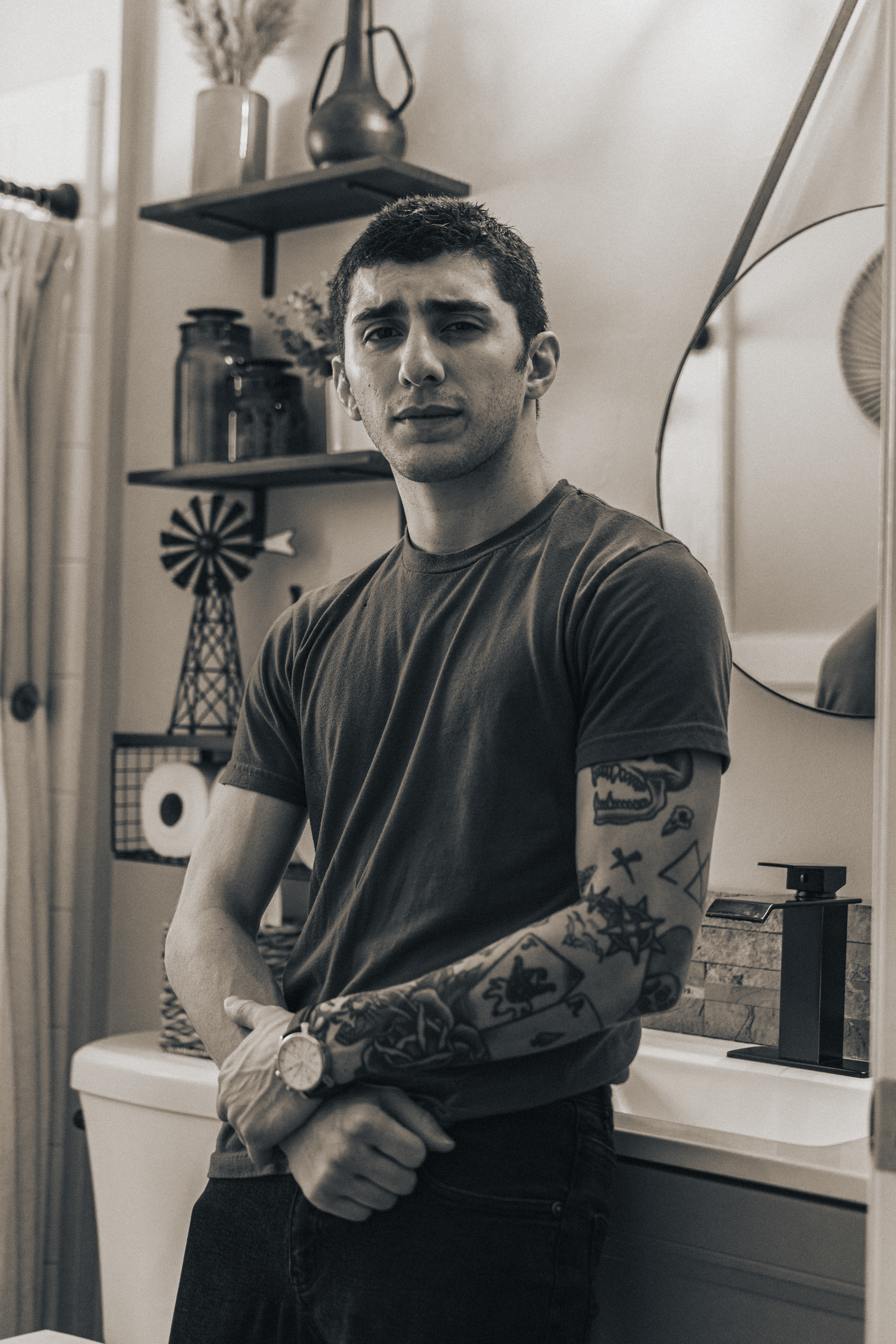@acey.15 | Moody bathroom portrait photoshoot with buzz cut men's haircut, patchwork tattoos, black and white