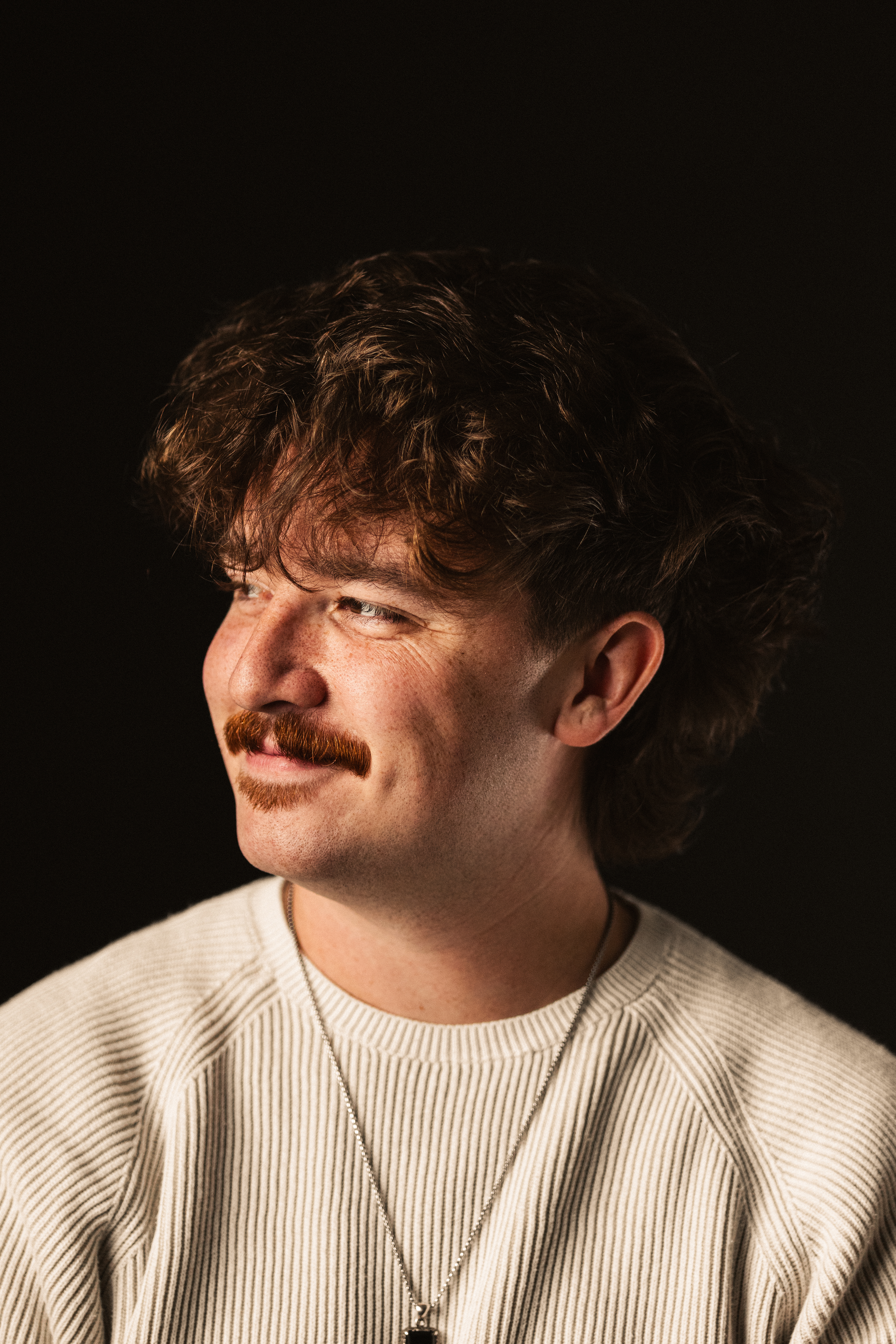 Portrait of Collin Frye | Black backdrop photography, smiling facing left