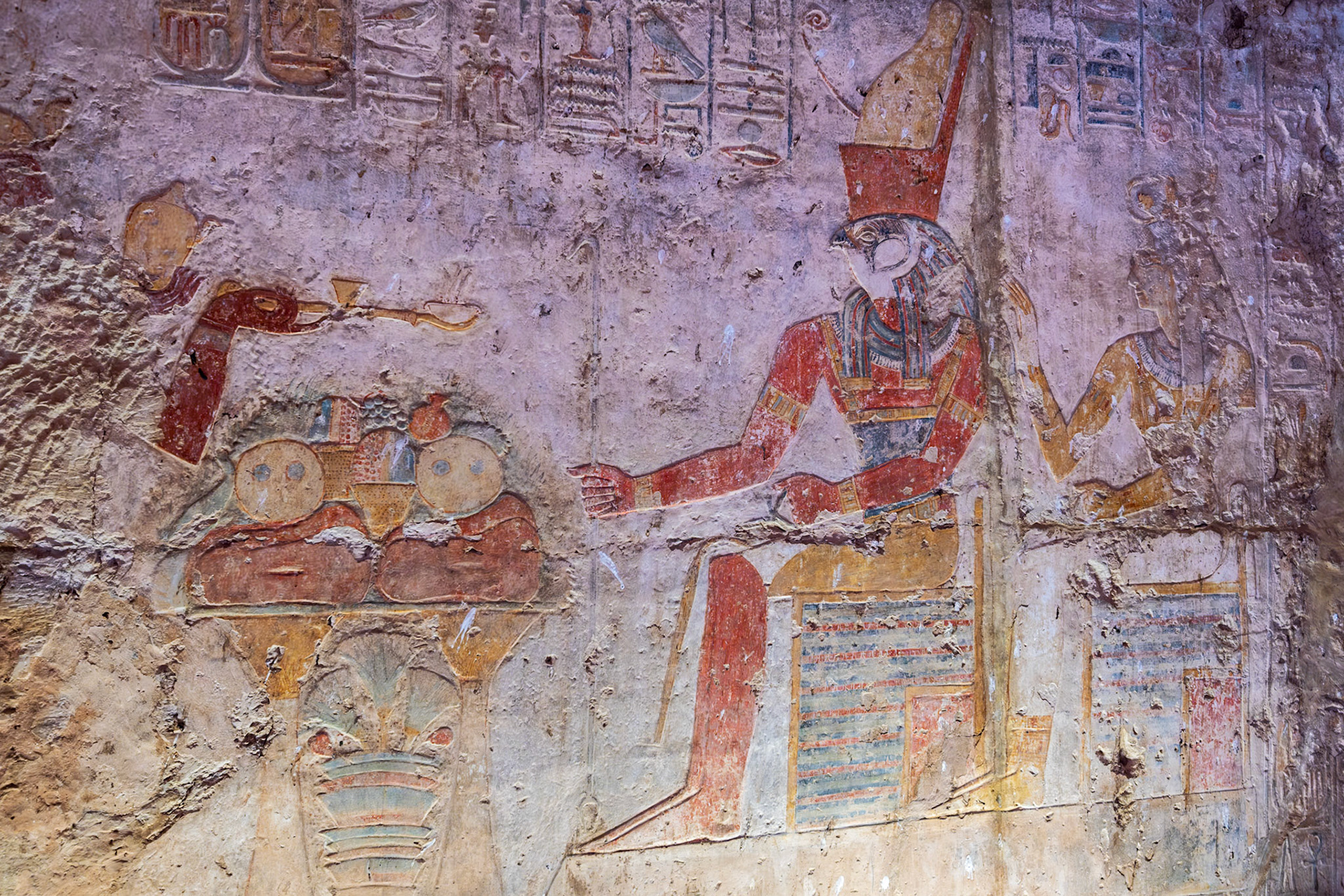 Ramsesses II attended by Hathor censing and libating a food offering before Horus and Isis