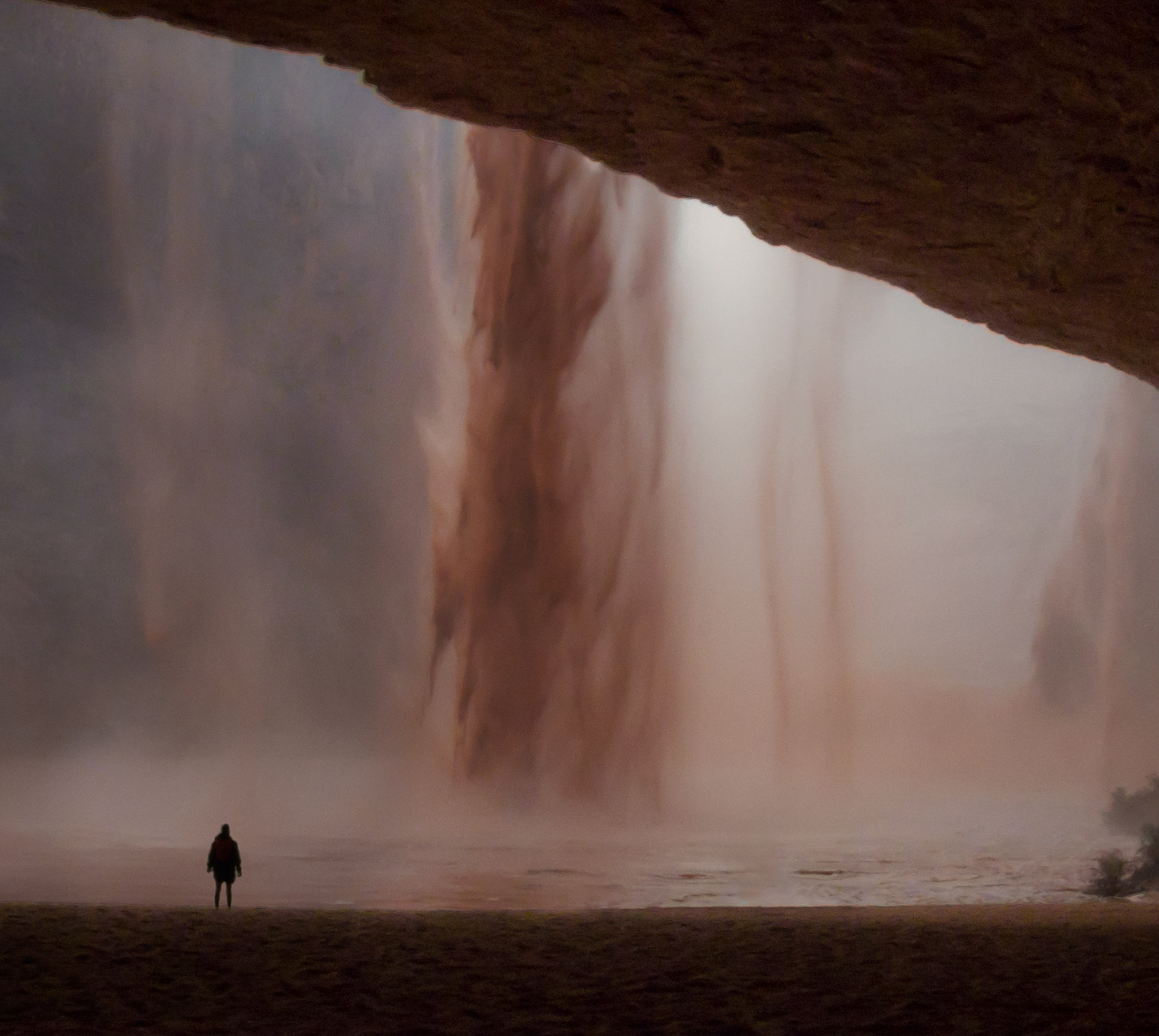 Flash flood pouring over the edge of Redwall Cavern into the Colorado River in the Grand Canyon.