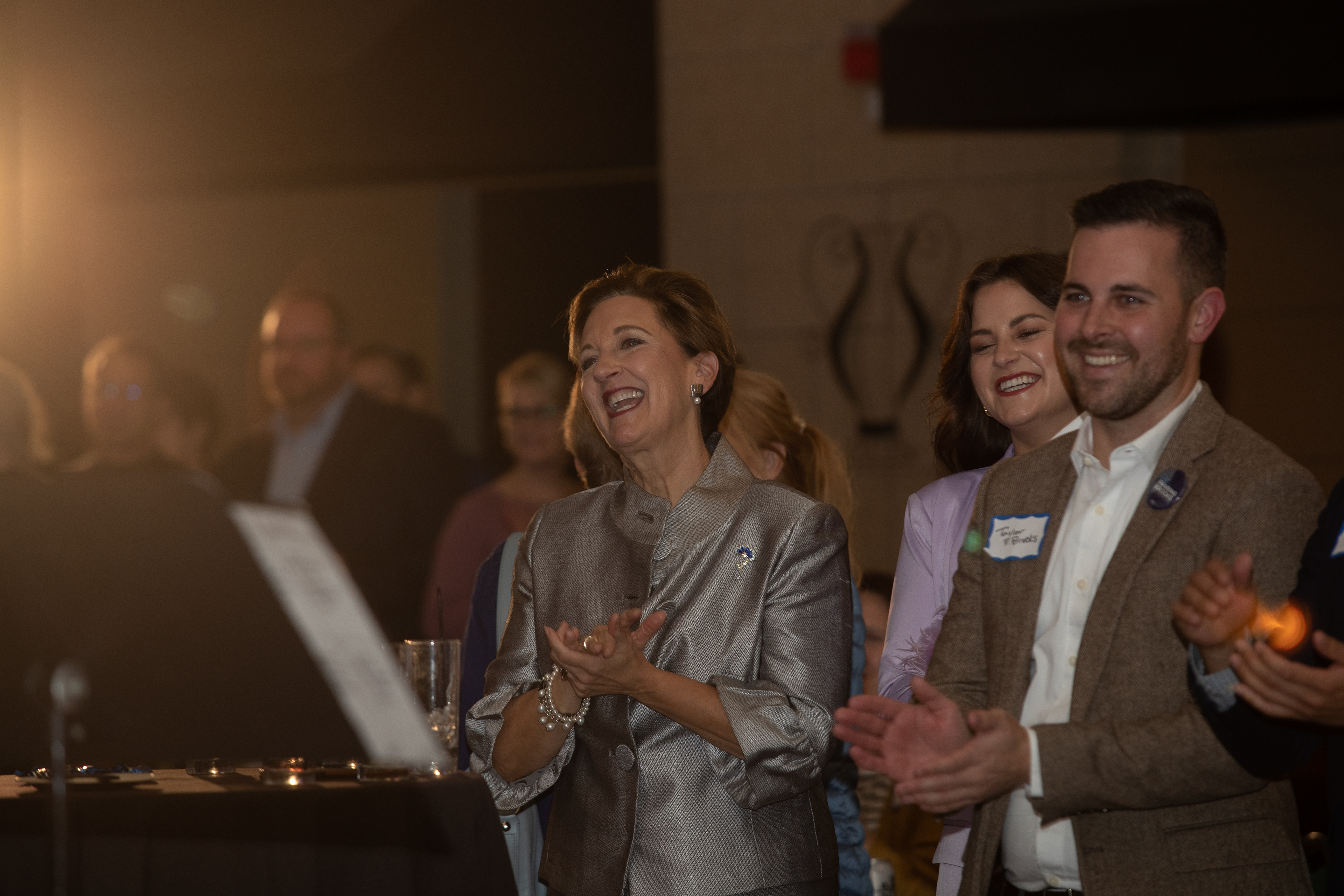 Patty Pansing Brooks claps for the Lincoln Queer Choir during her election night party at Lincoln Station Great Hall on Nov. 8, 2022. Two of her three children, Taylor Brooks and Avary Pansing Brooks, are pictured to the right. (Nebraska News Service / Naomi Delkamiller)