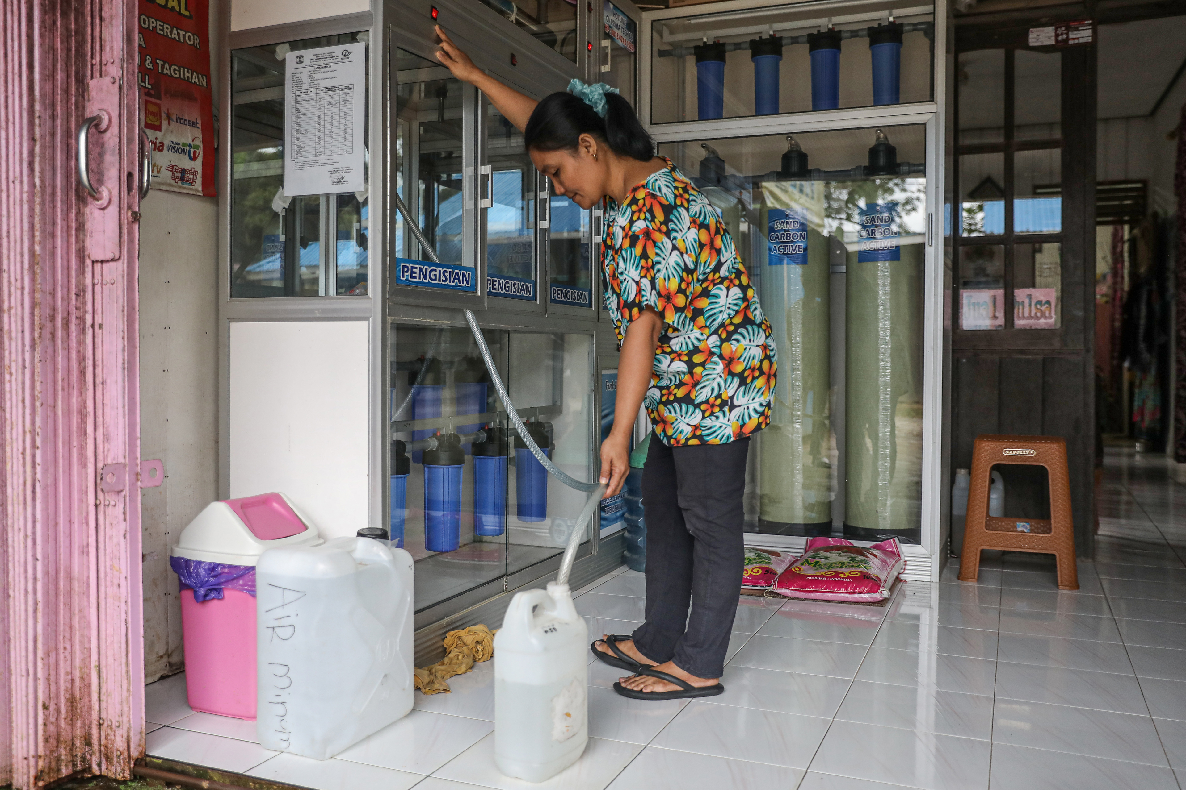 Ratna Ajeng (43) refills clean water at her shop in the Sepaku area, Penajam Paser Utara, East Kalimantan, Indonesia.