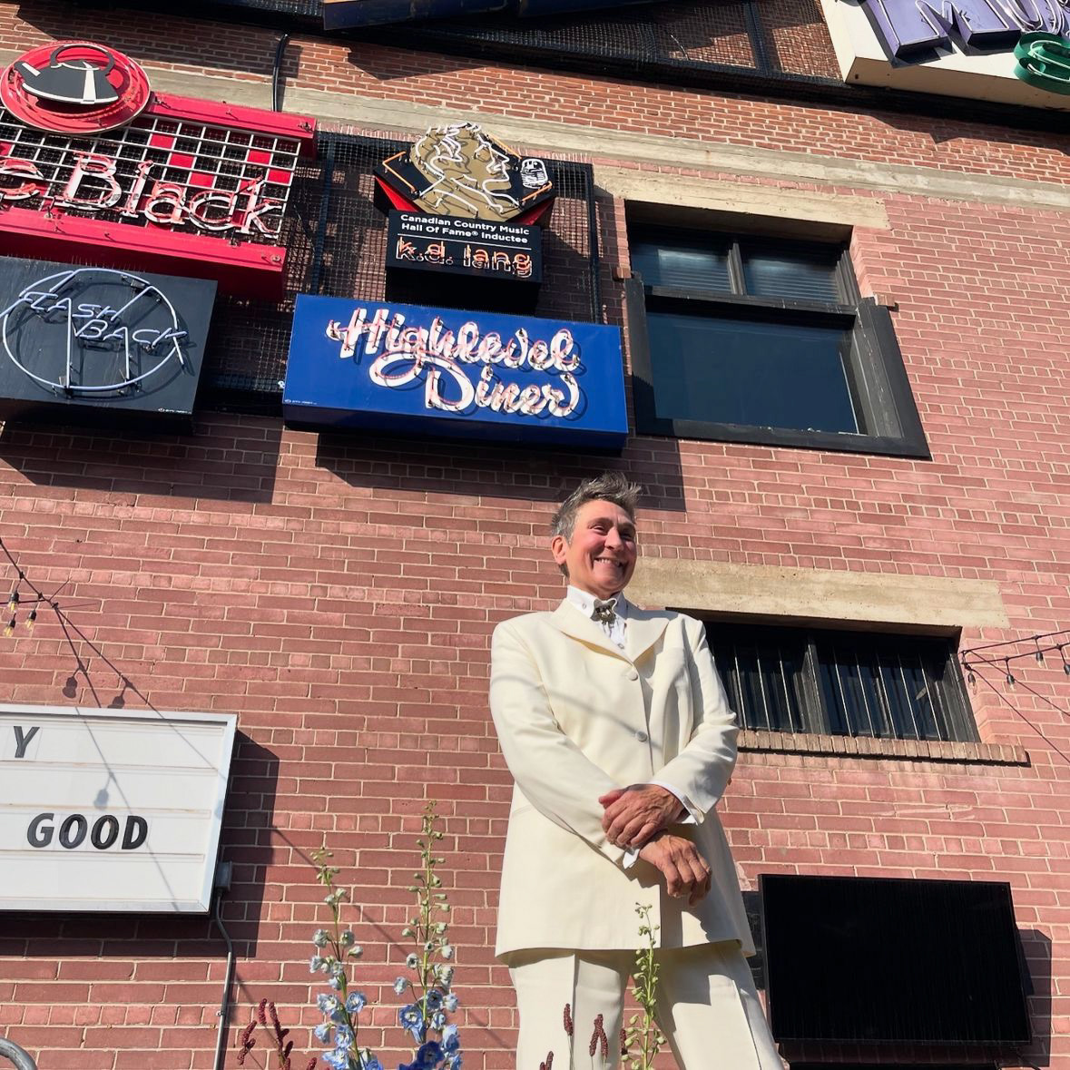 k.d. lang in front of the installed sign at Edmonton's Neon Sign Museum