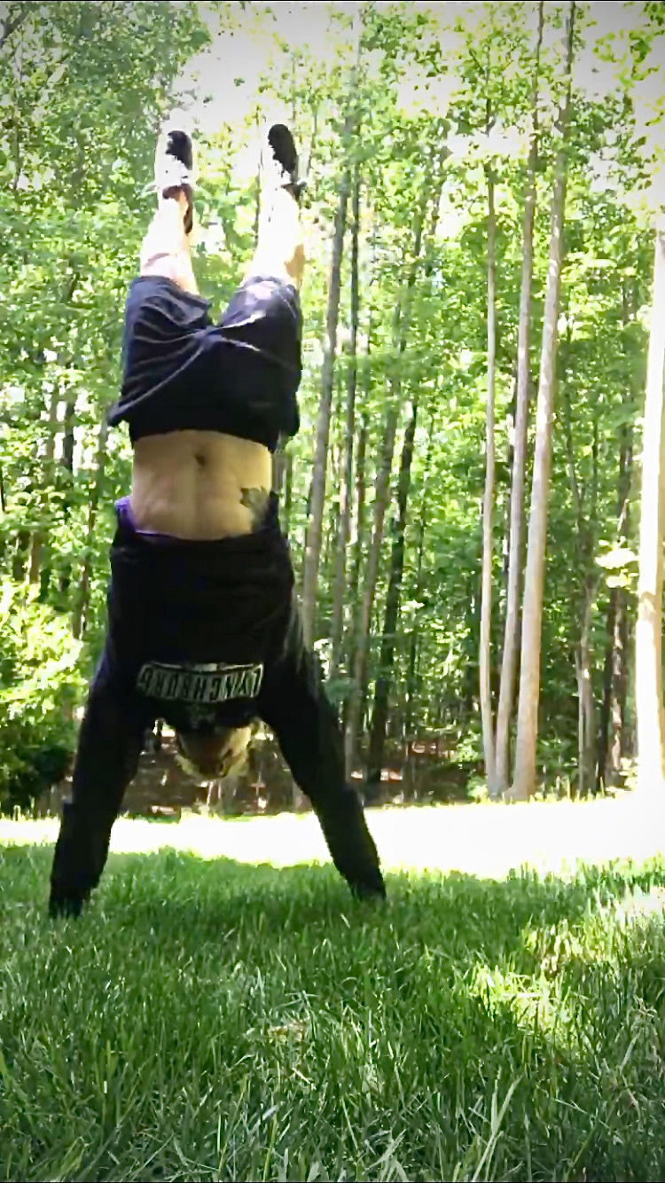 Erik Oehler doing a handstand in his back yard to work on his upper body strength while away from the gym, May 6th, 2020. Erik Oehler | Clayton, North Carolina.