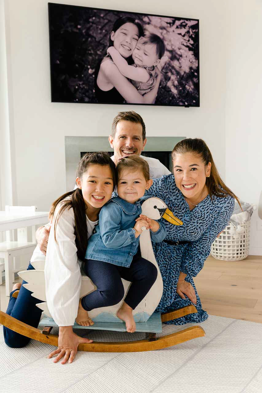 Ein Familienporträt vor einem Kamin – die Eltern und Kinder strahlen Herzlichkeit und Harmonie aus.