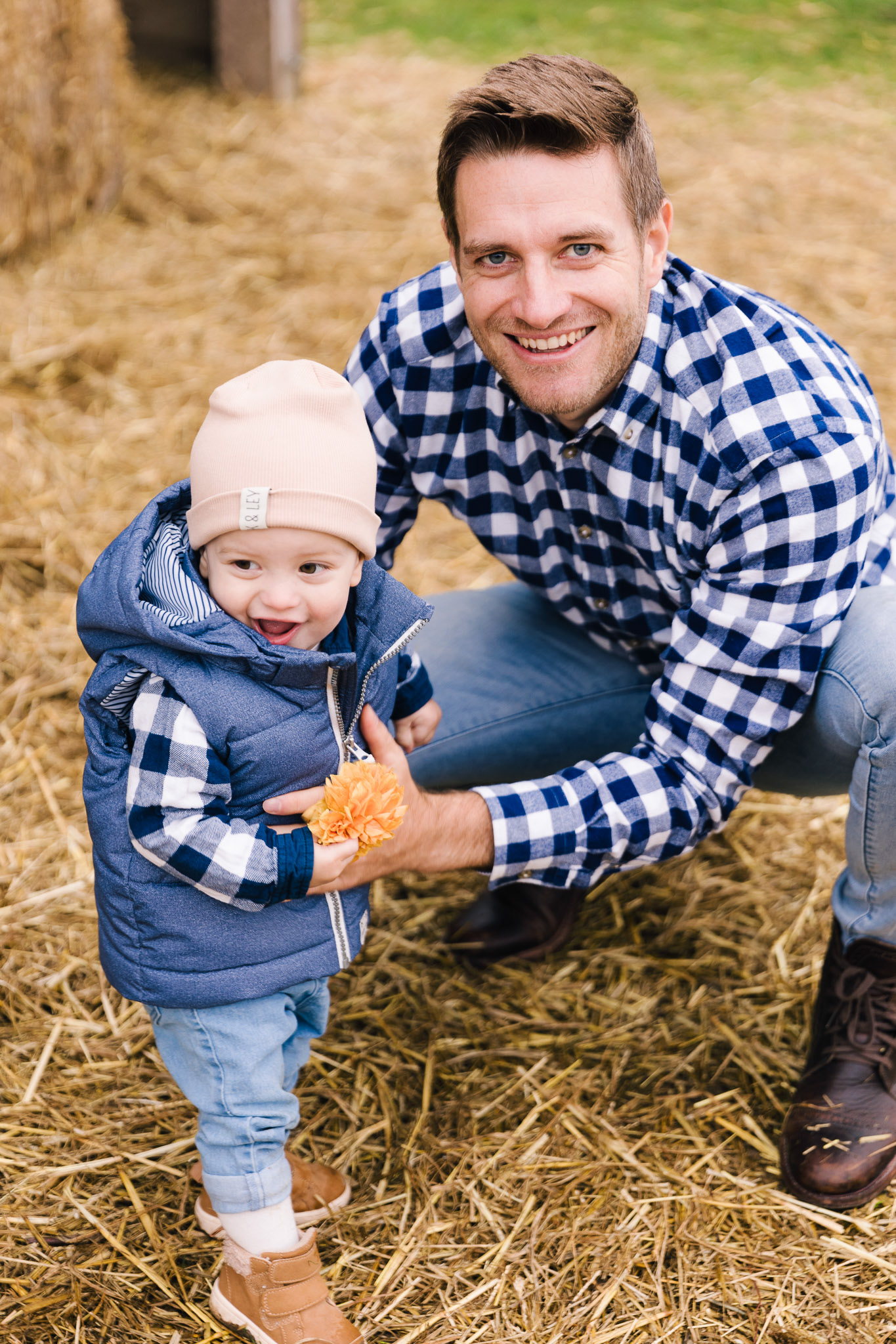 Familienfotografie: Vater und Sohn in karierten Hemden, lachend und spielerisch im Herbstlicht