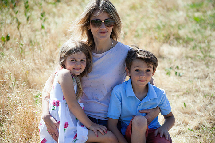 outdoor portrait of mother embracing daughter and son
