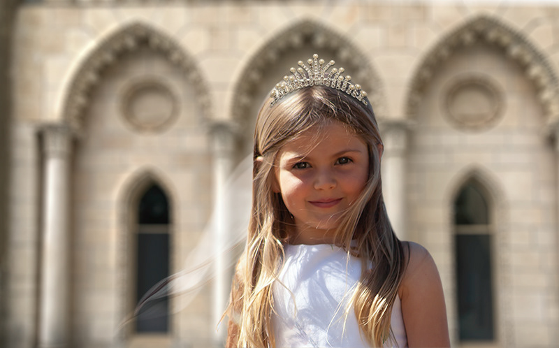 Catholic first communion photograph of girl wearing crown in front of  Castle