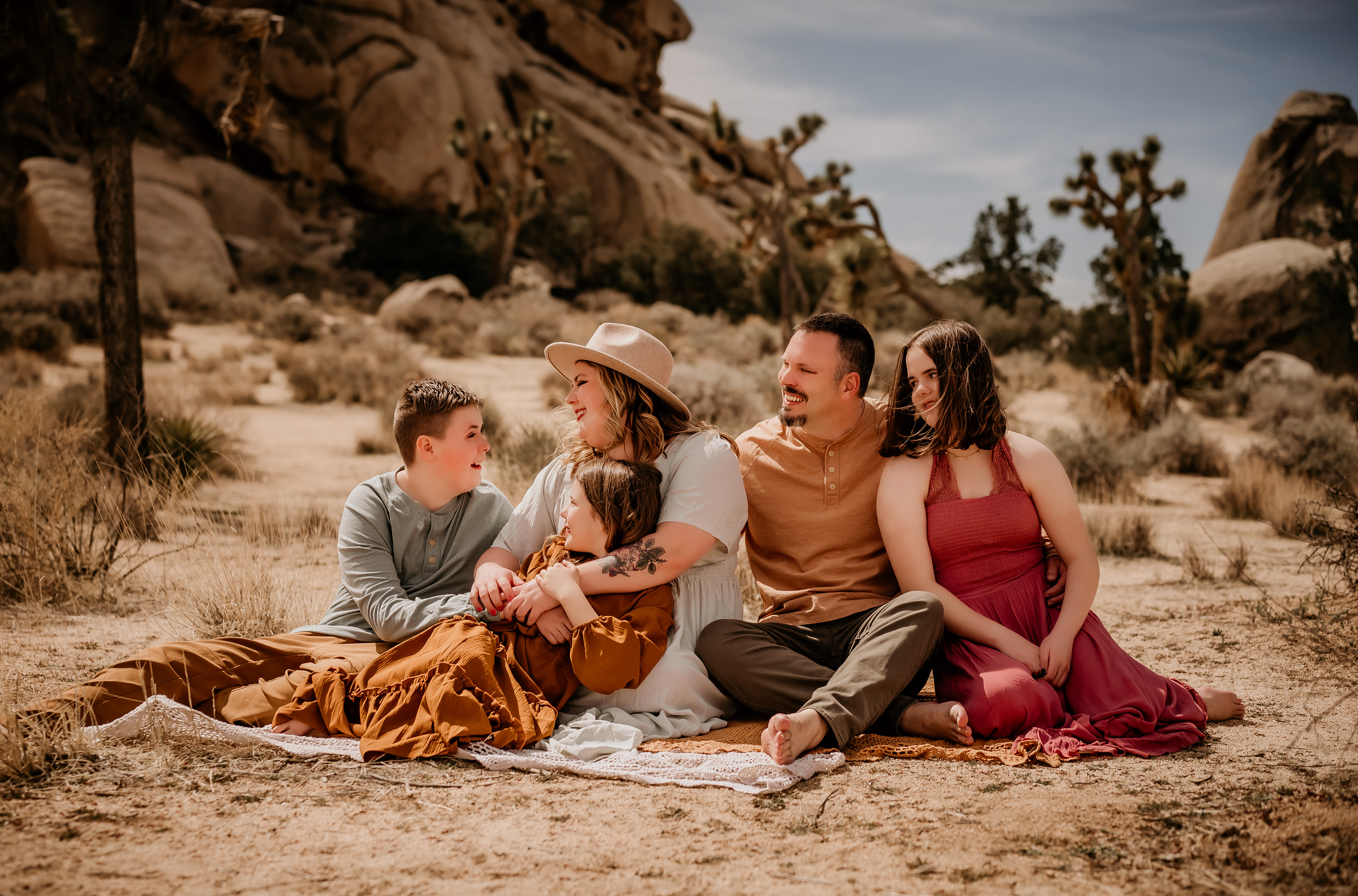 Family of five sitting on a blanket. Picture was taken by Hearts and Arrow Photography. This was a family session in Joshua Tree, California