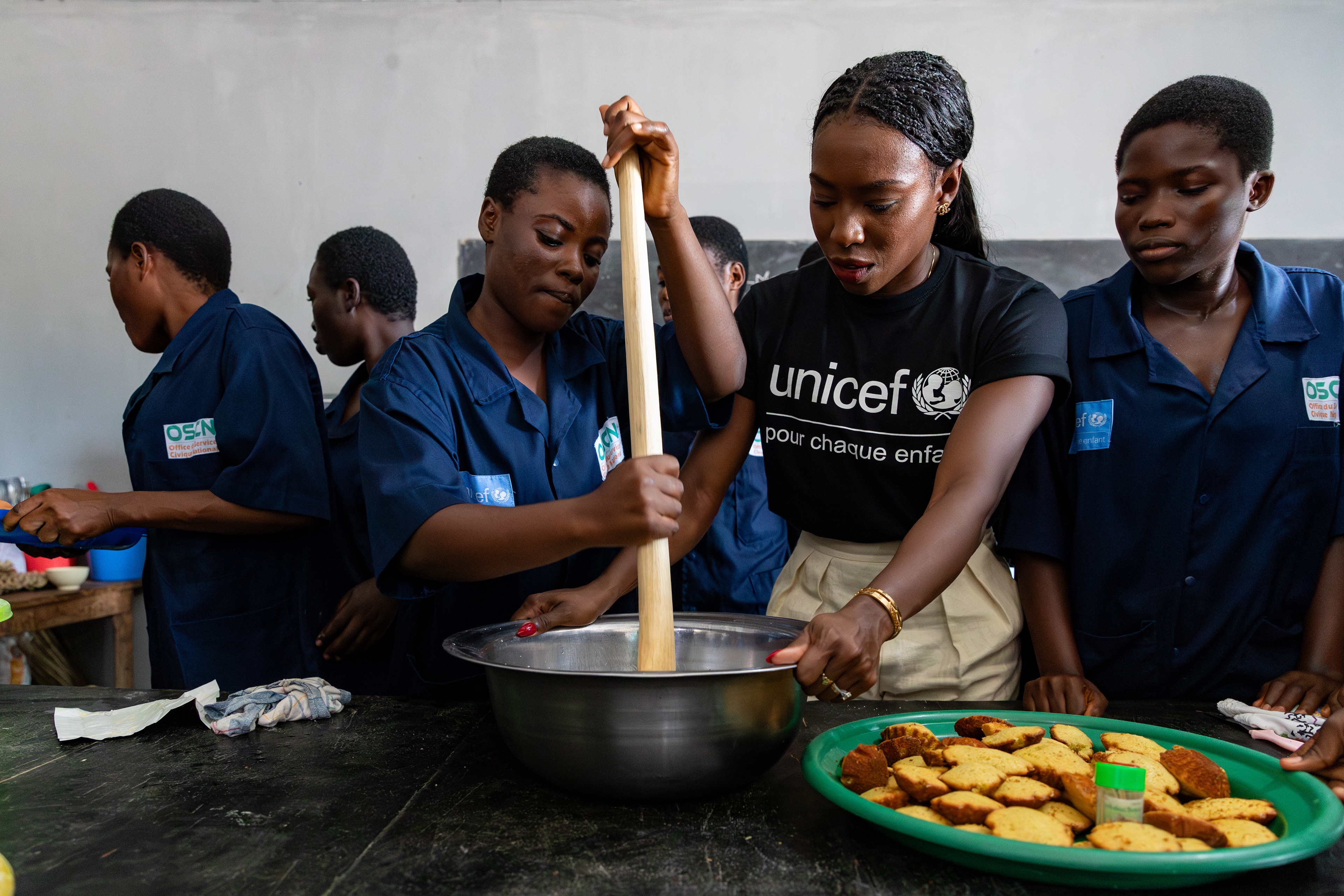 On 15th October 2024, at the Centre Civique d’Action pour le Développement in Guédikpo, South-West Côte d’Ivoire, UNICEF Ambassador Murielle Ahouré Demps participates in a pastry class, making a cake alongside the girls as part of the Girl Power project. Captured by Miléquêm Diarassouba, Photojournalist West Africa. 