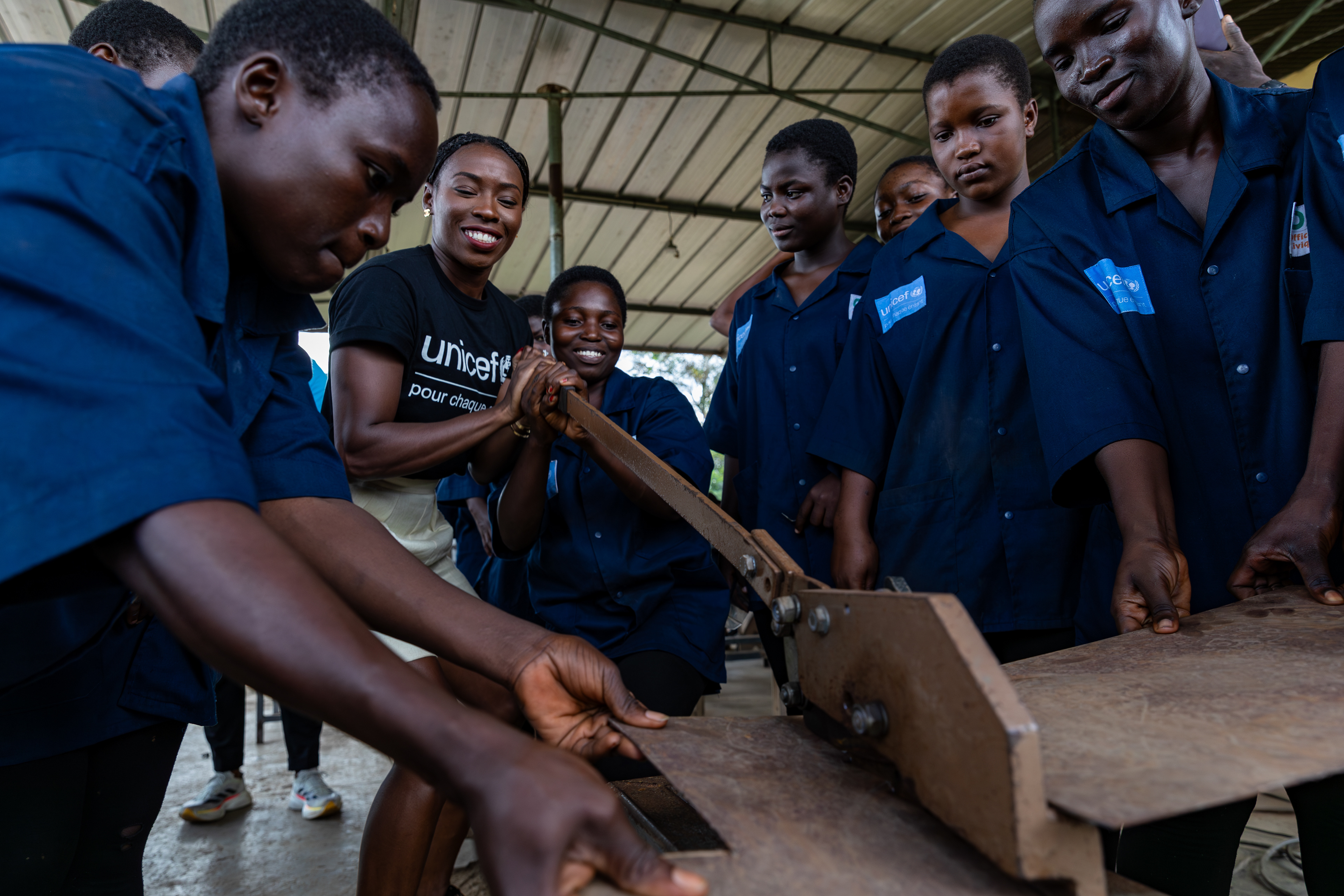 On 15th October 2024, at the Centre Civique d’Action pour le Développement in Guédikpo, South-West Côte d’Ivoire, UNICEF Ambassador Murielle Ahouré Demps cuts metal while the girls from the blacksmithing class hold the piece steady during her visit. Captured by Miléquêm Diarassouba, Photojournalist West Africa.