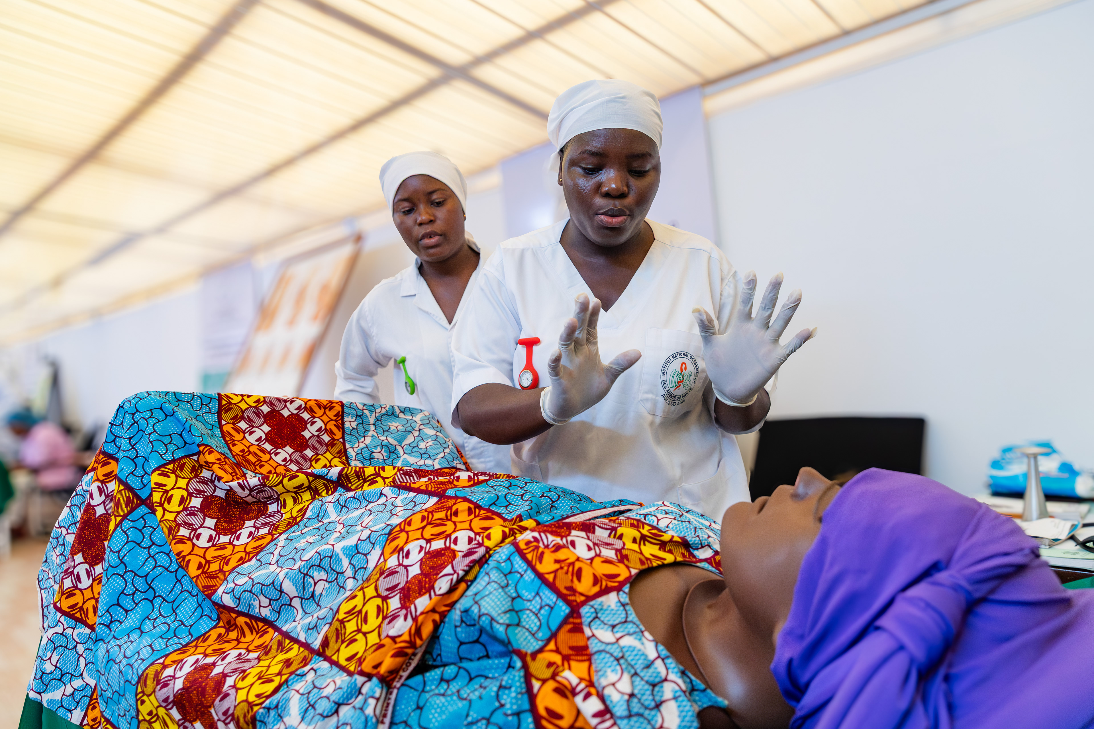Midwifery students Kanga Sara Eunice and Assi Ange conduct a joint simulated prenatal consultation during a training session at the Institut National de Formation des Agents de Santé (INFAS) in Abidjan on 9 September 2025. Together, they assessed the condition of a simulated patient to ensure the health of both the mother and the baby.