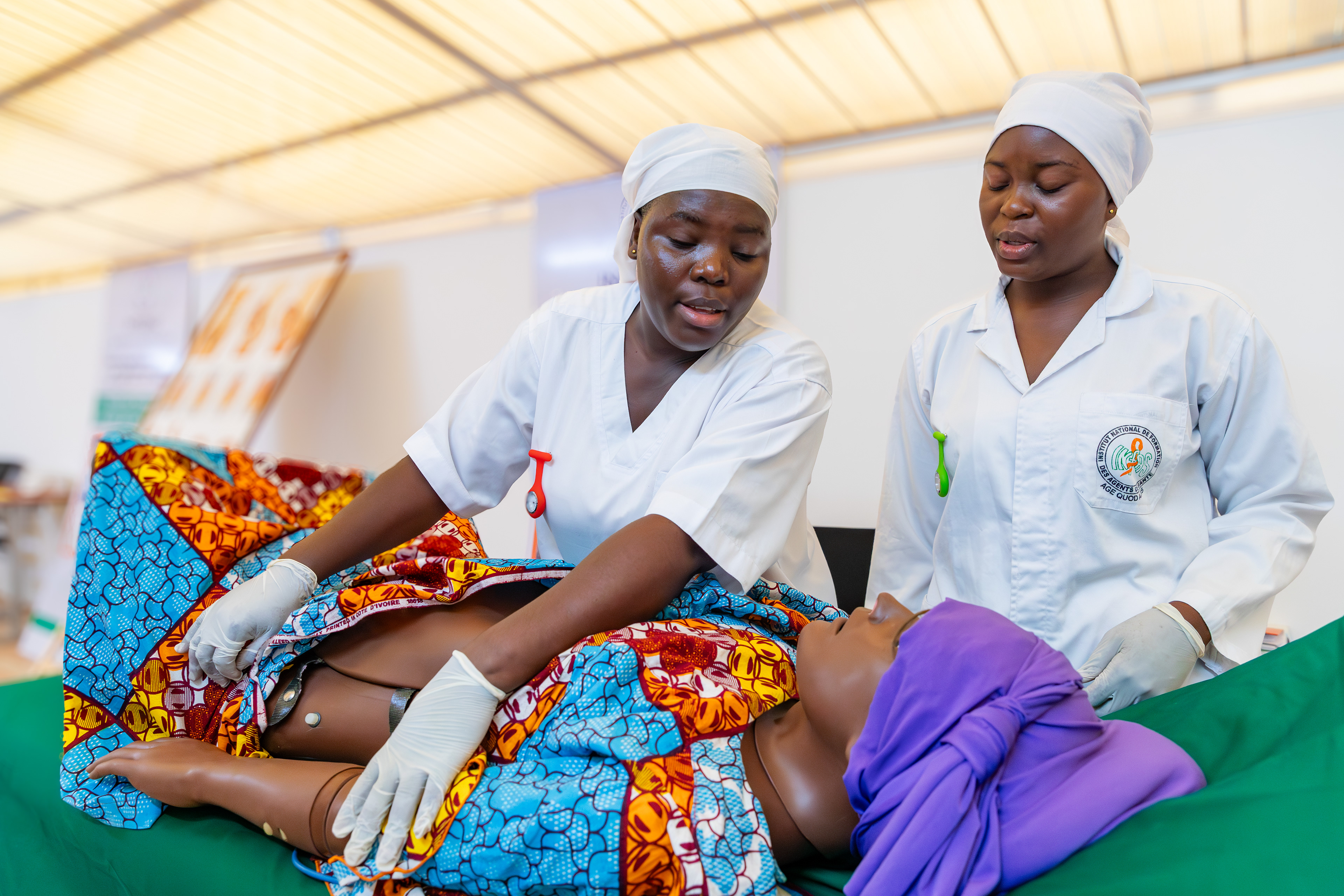 Midwifery students Kanga Sara Eunice and Assi Ange conduct a joint simulated prenatal consultation during a training session at the Institut National de Formation des Agents de Santé (INFAS) in Abidjan on 9 September 2025. Together, they assessed the condition of a simulated patient to ensure the health of both the mother and the baby.
