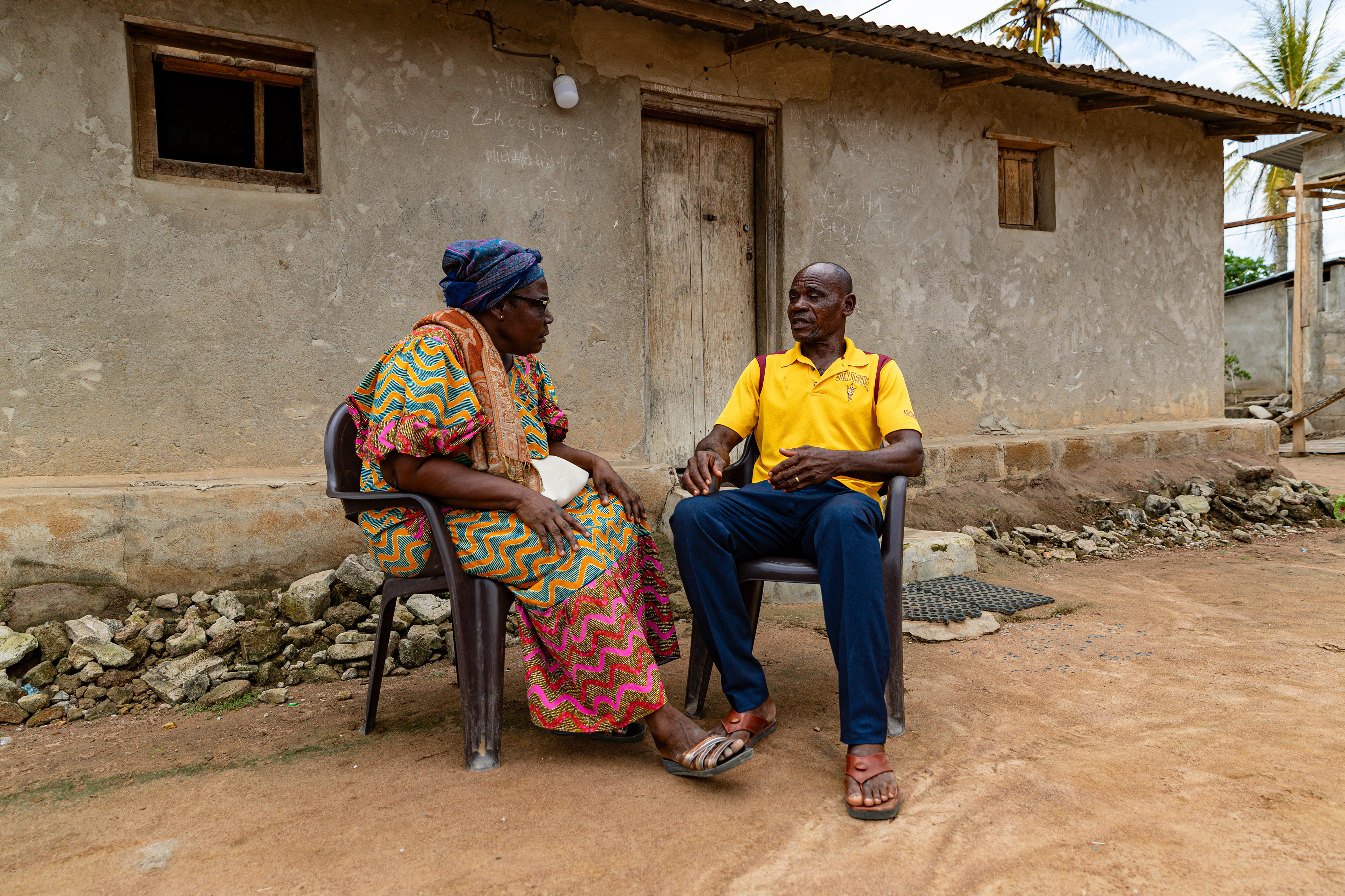 Digbeu Zeze Sylvain, a DREAMS Godfather, talks to Digbeu Cecile, a friend and DREAMS Godmother, in Zokoguhé, a village 18 km from Daloa in western Côte d'Ivoire, on 29 June 2024.