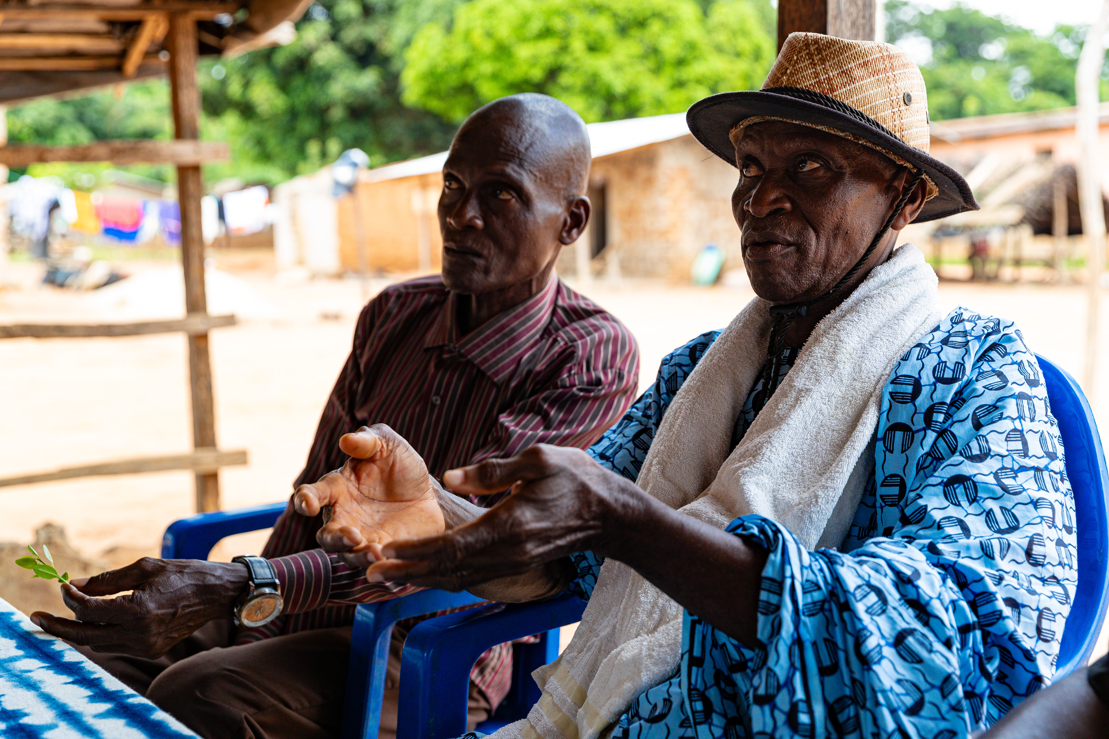 Ziza Boli Jean Jacques, village chief, listens to his advisor, Digbeu Zeze Sylvain, during a meeting in Zokoguhé, a village 18 km from Daloa in western Côte d'Ivoire, on 29 June 2024.