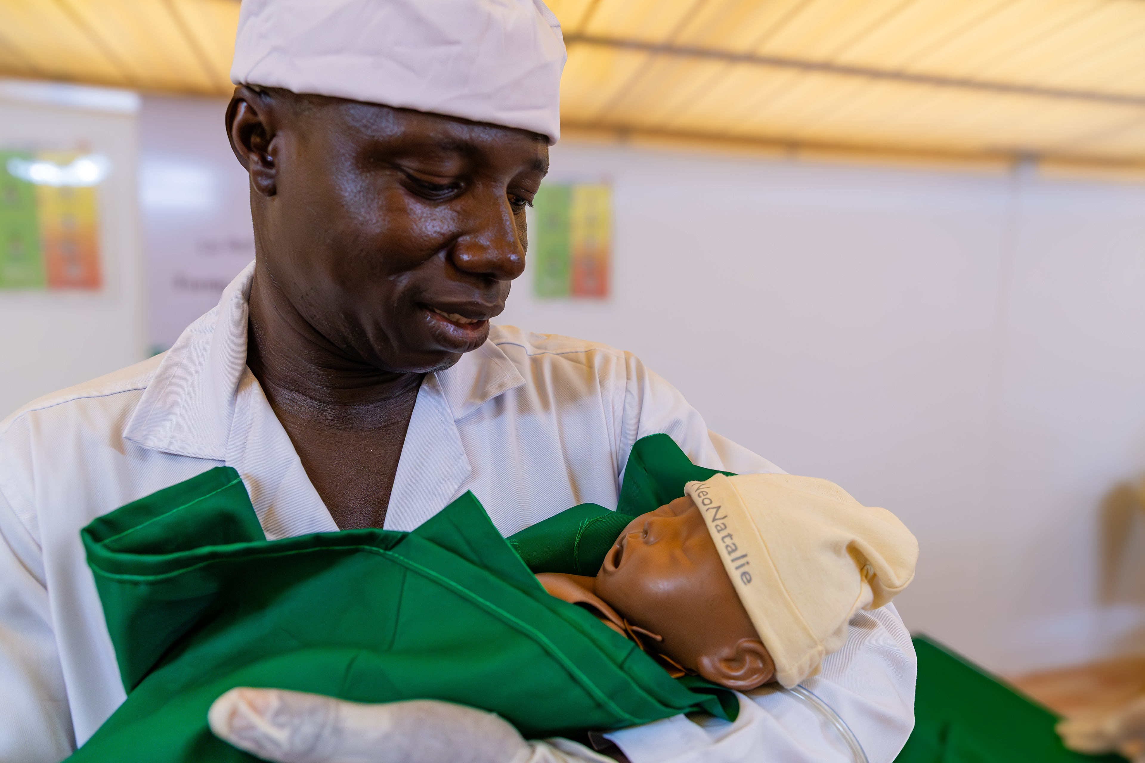 Sonan Franck Emmanuel, 29, midwifery student at INFAS, poses with a neonatal mannequin after a simulation exercise in Abidjan on 9 September 2025. The session demonstrated how students are trained to perform life-saving resuscitation techniques when a newborn is not breathing properly.