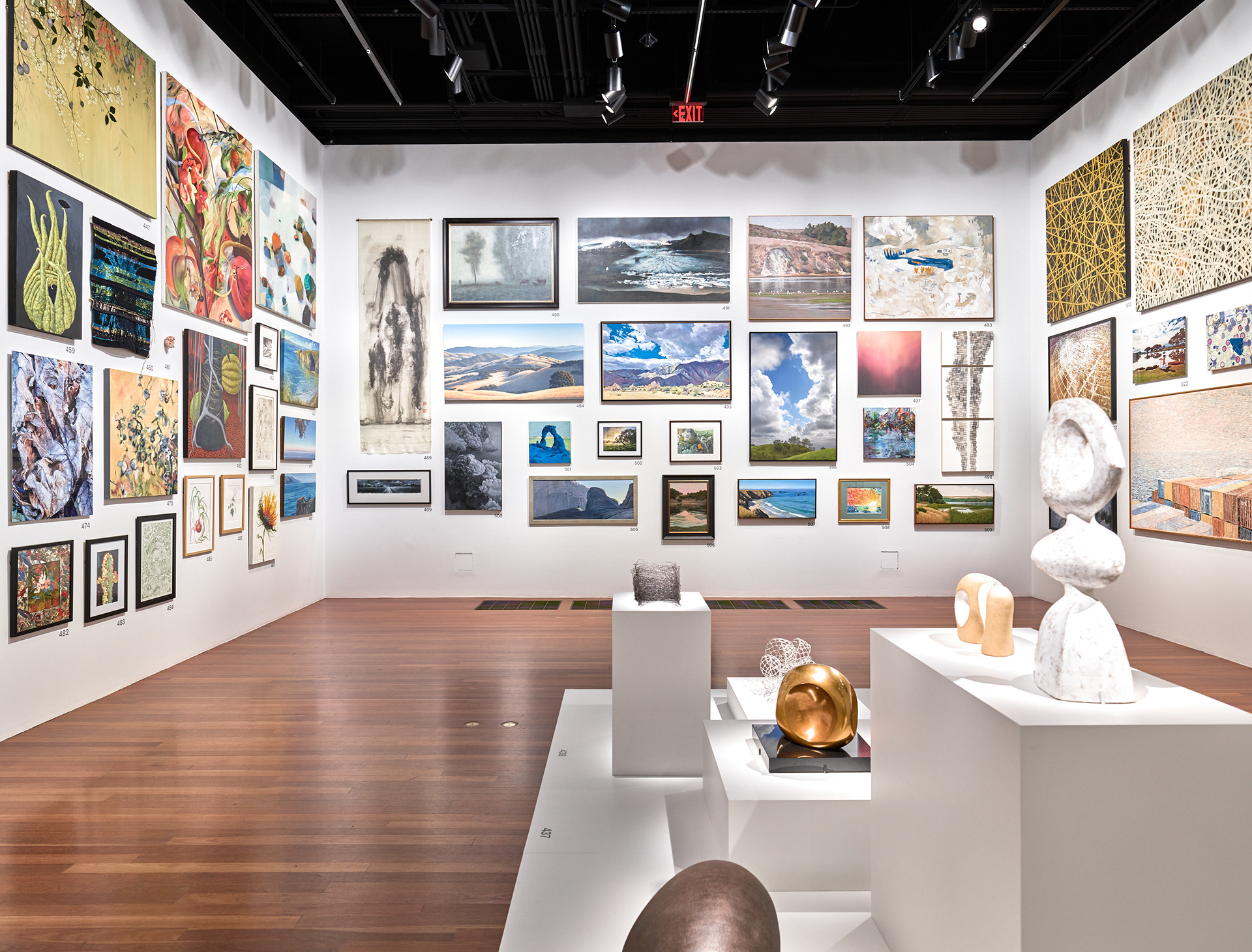 Integrated display of two- and three-dimensional works within a unified gallery composition.