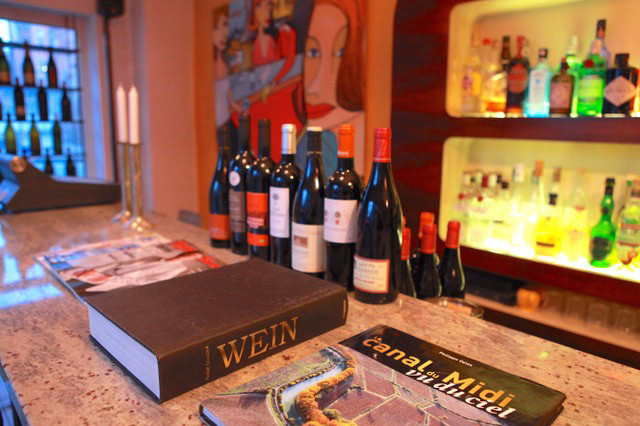 Canal du Midi Weintheke mit Weinflaschen stehend und Buch über Wein