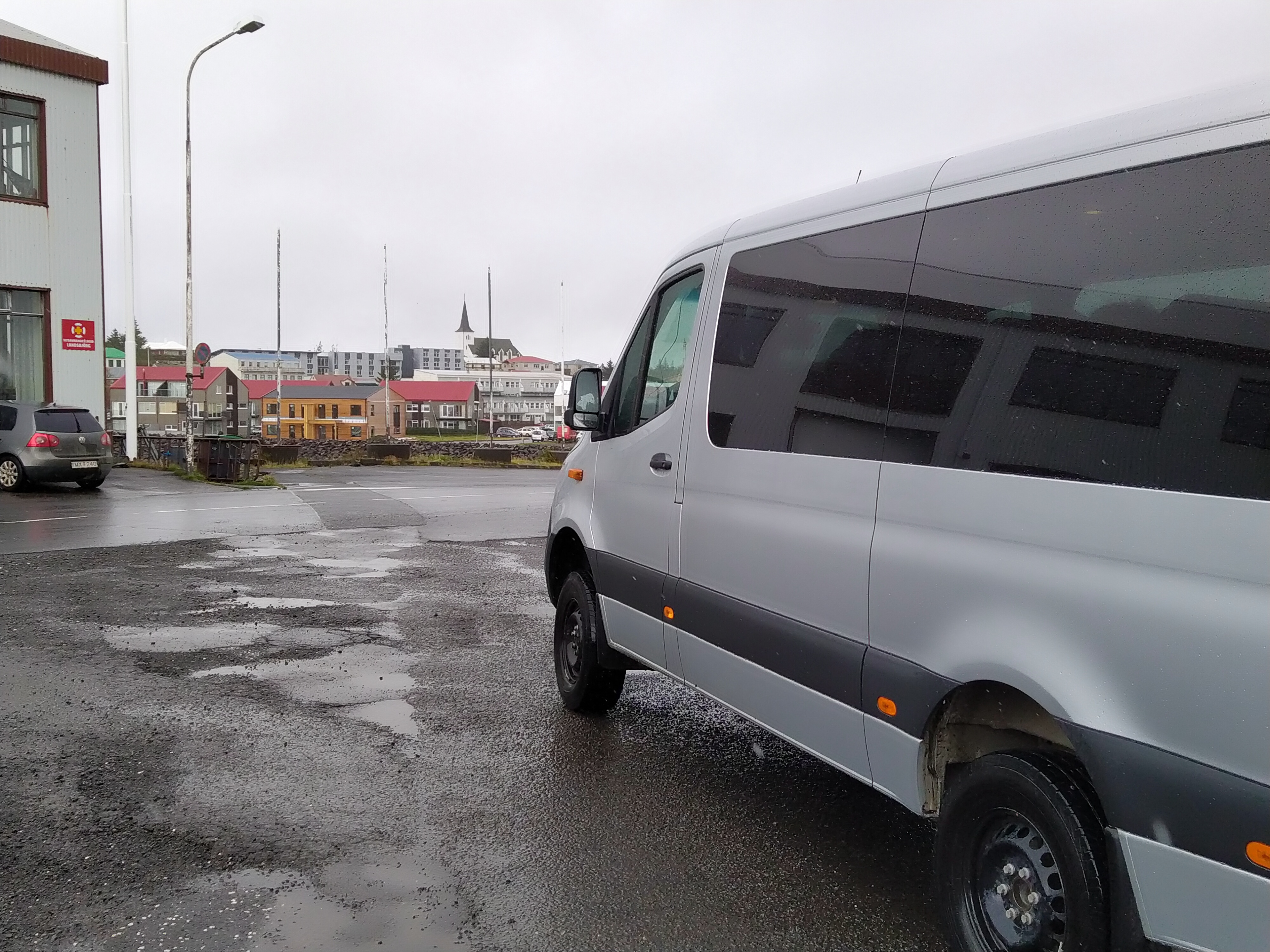 Kuvassa pikkubussimme sekä näkymä kylään