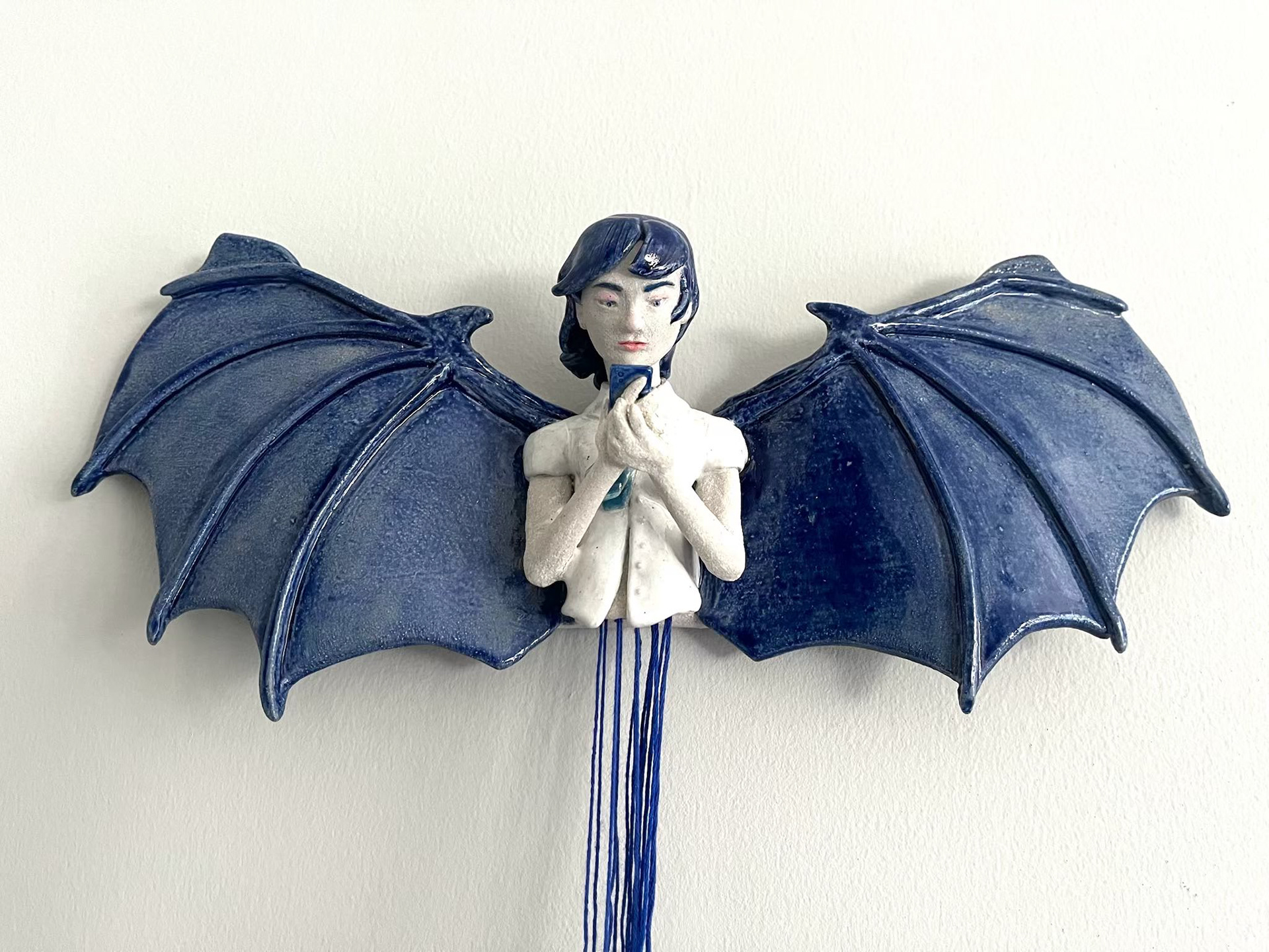The Manananggal is a creature that detaches itself from the lower half of their body to fly off to find their victims at night. The lower body is hidden but vulnerable to attack.  This piece is made of ceramic and thread representing many themes that resonate with me personally. Like the detachment I felt from leaving a country I once called home. Forever split and missing a part of my identity along with finding it difficult to connect with others. The long threads represent a few hopeful links that may help guide the way.