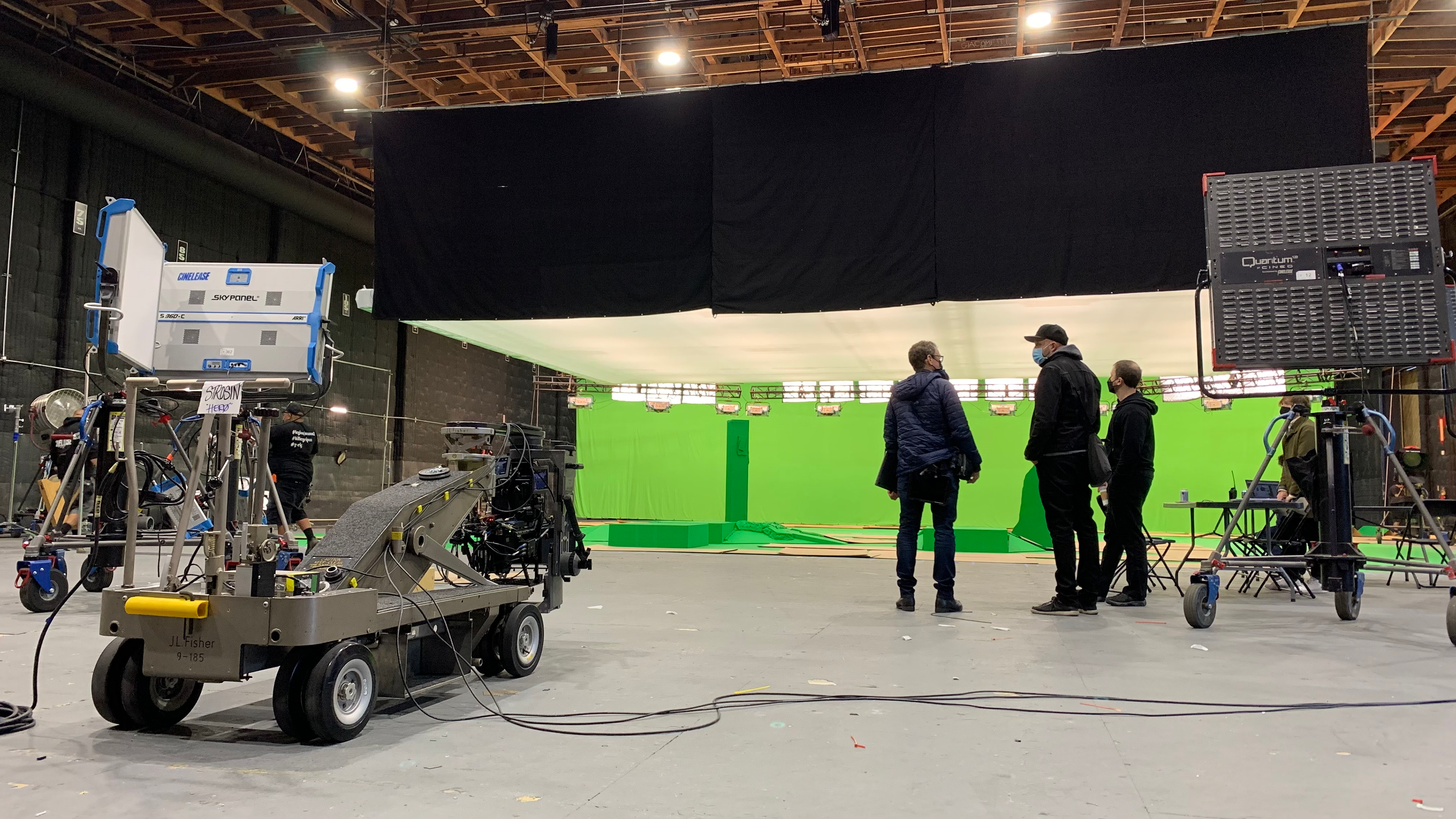 Film crew and camera dolly on a soundstage with a green screen during production of the Stranger Things 3D finale