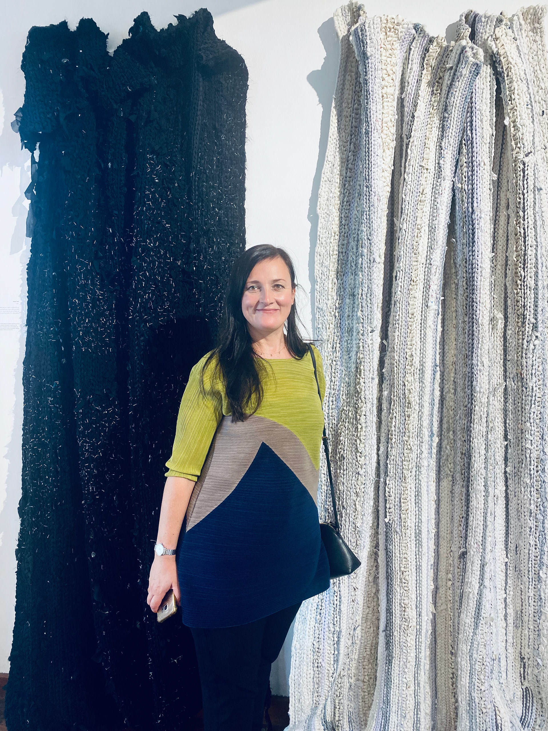 Irina Kotova with her hand woven carpets made by stitching together her daughters t-shirts and friends abayas then filling them with staples that make them hostile to touch