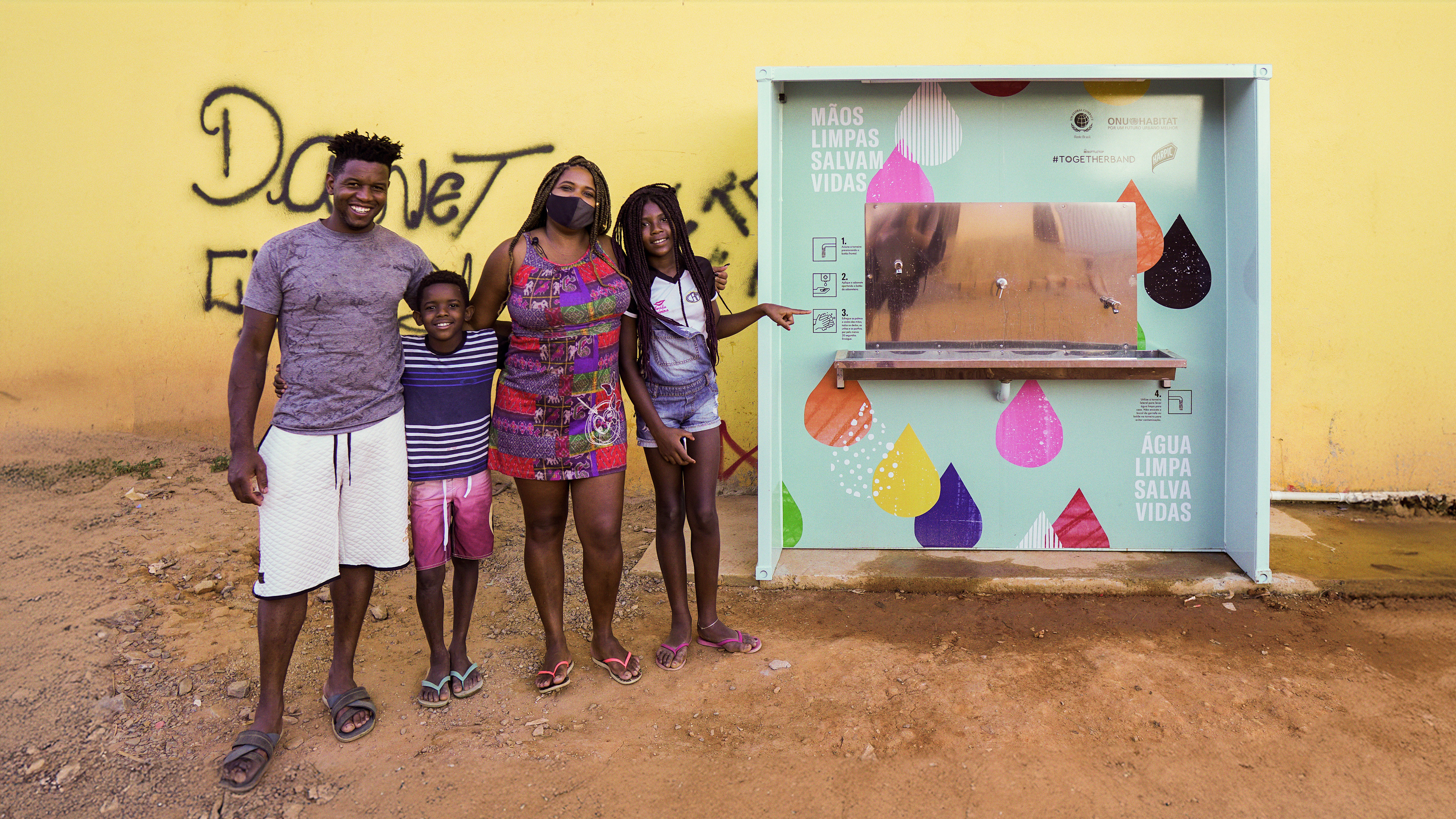 Happy people stood next to a hygiene station