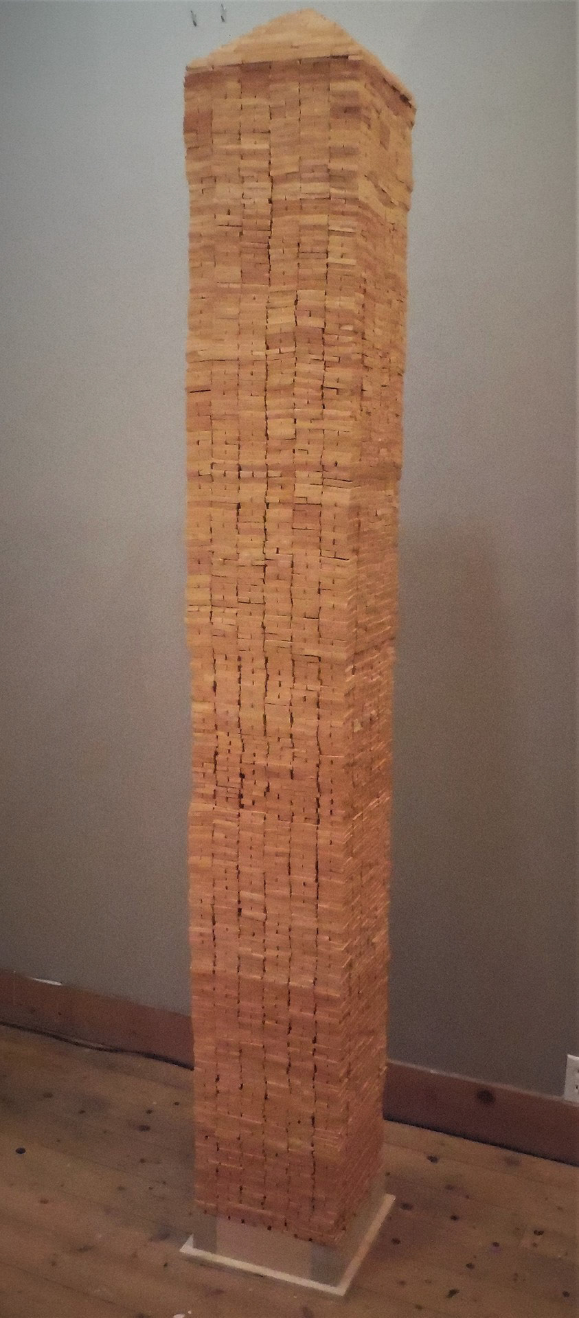 2" x 1" x 1/4" low fire glazed hand made tiles stacked to form a 7' column of lies.