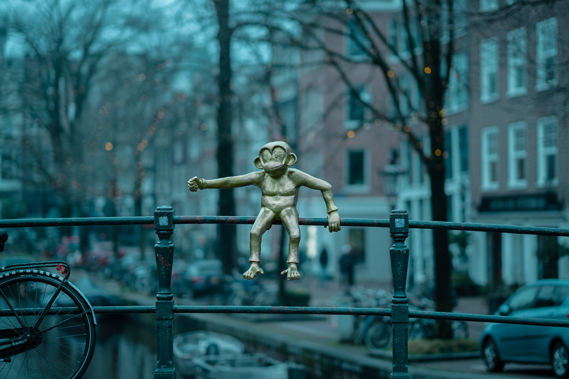 Monkey on a canal bridge in Amsterdam greating tourists.