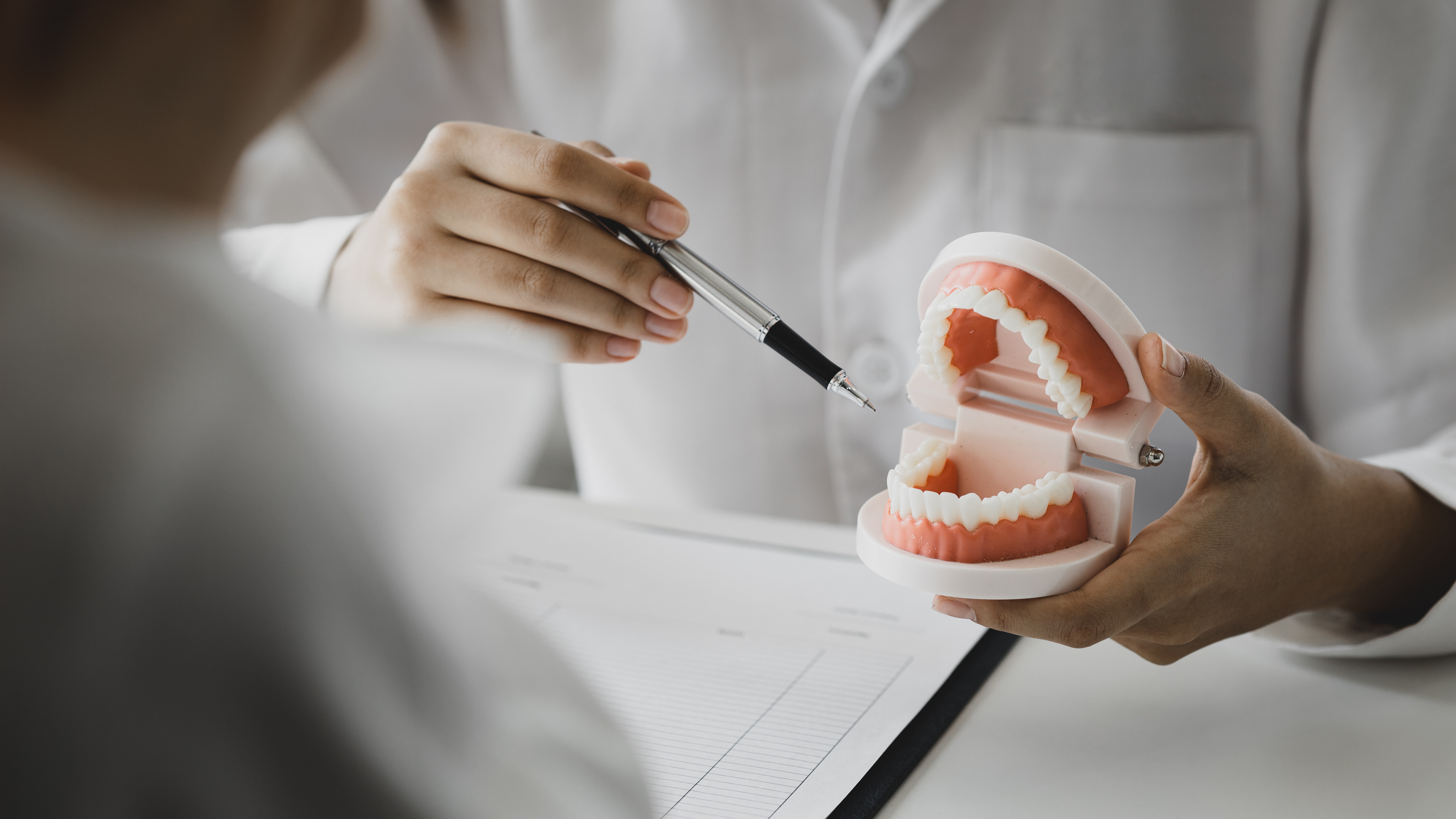 Dr. Nidhi Vyas, a friendly and experienced dentist from The Dental Lounge in Indore, Madhya Pradesh, India, engaging in dental education. She is pictured using dental models and tools to explain various dentistry concepts and treatments to patients, highlighting the clinic's commitment to patient education and oral health awareness.