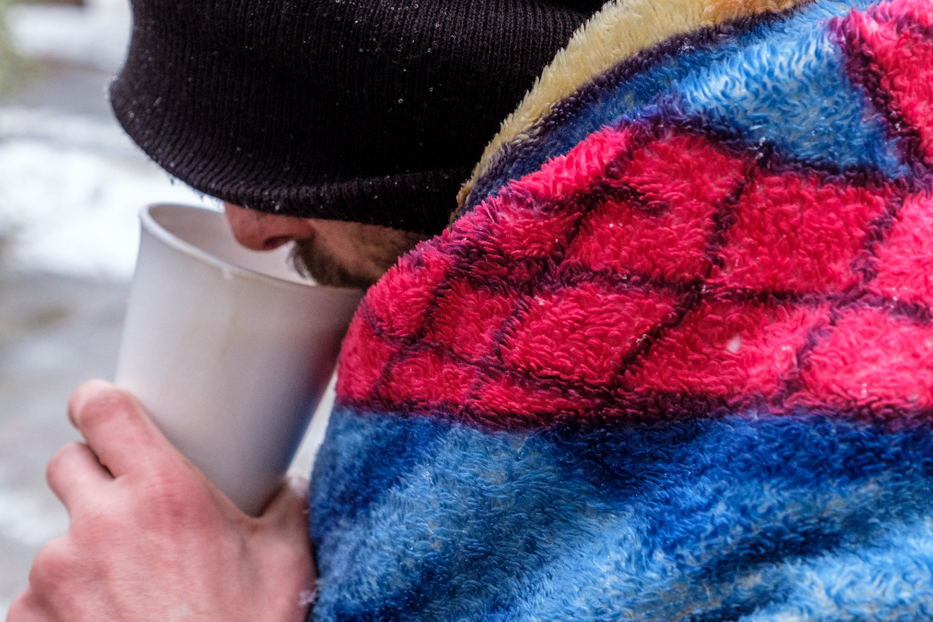 A rough sleeper with a hot drink on a cold morning at the Archer Project, Sheffield