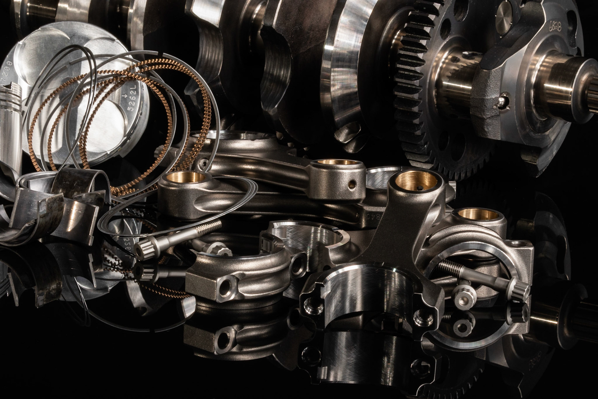 engine parts from a racing motorcycle on a black reflective background